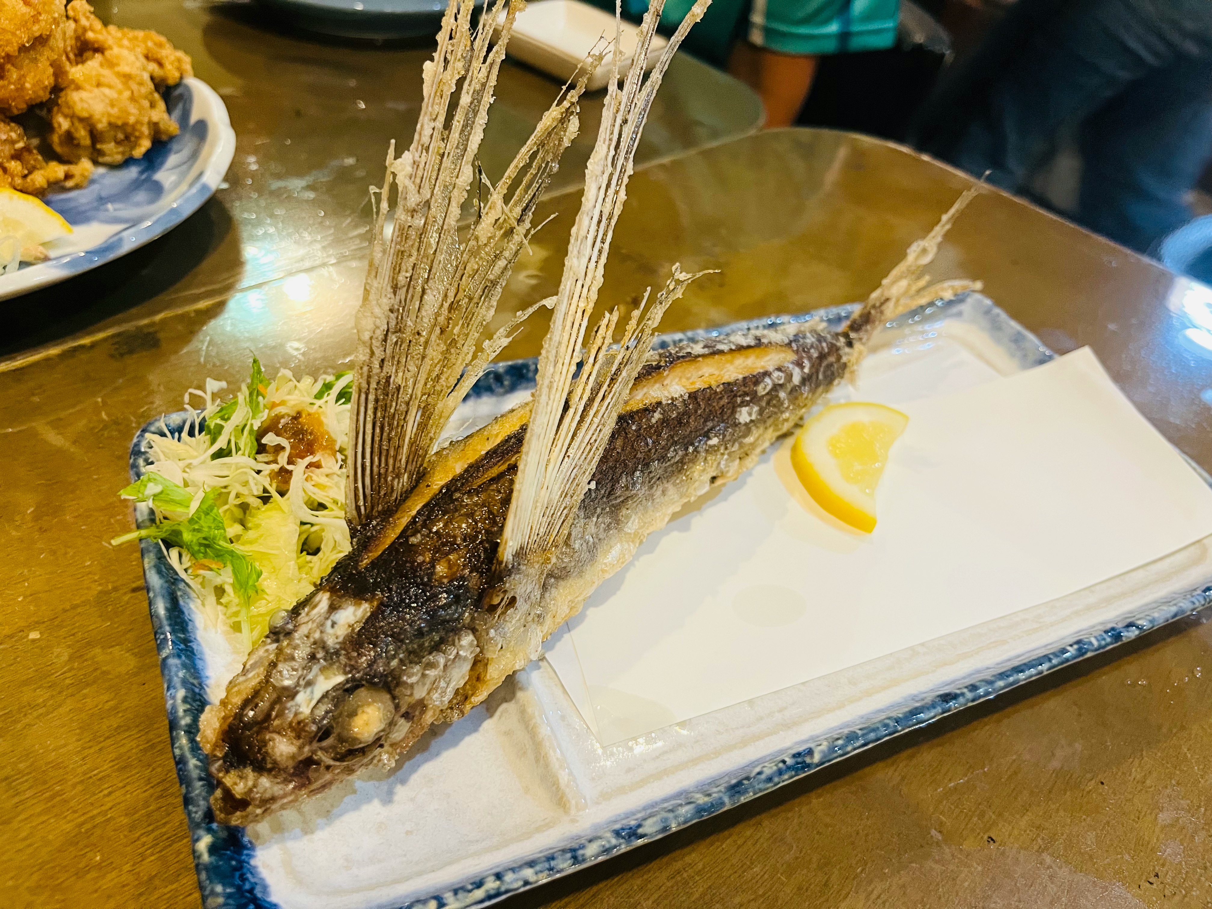 骨付き魚のグリルとレモン添えの食卓