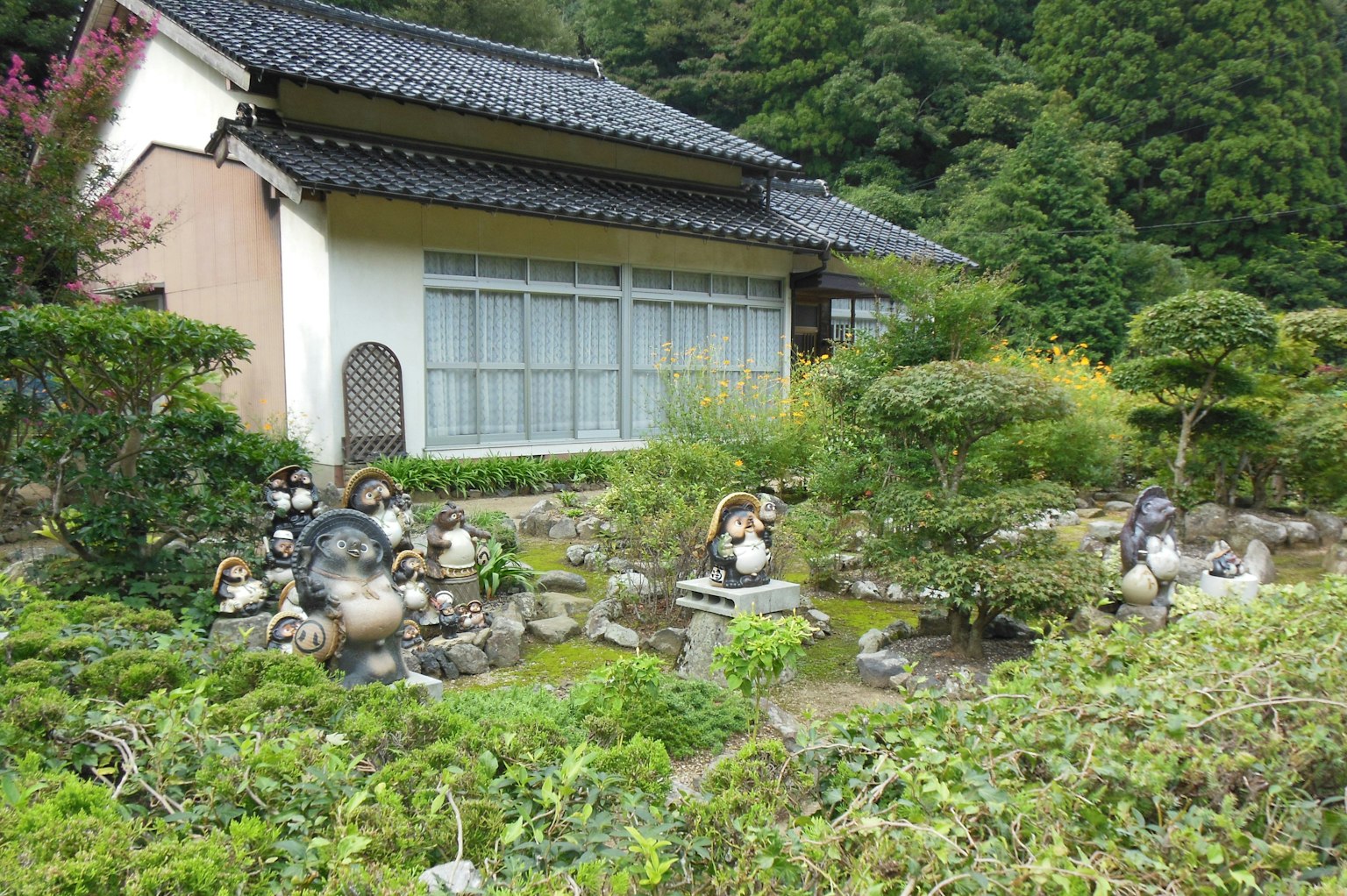 傳統日本房屋被郁郁蔥蔥的花園和石雕環繞