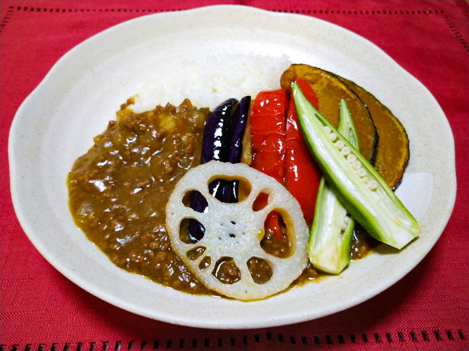 Curry de verduras servido en un plato blanco con verduras coloridas