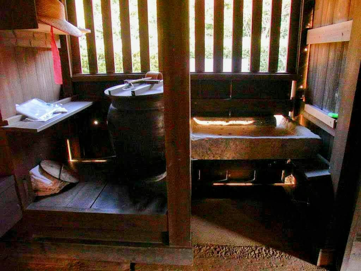Interno di una tradizionale casa da bagno in legno con una vasca in pietra e un portasciugamani in legno