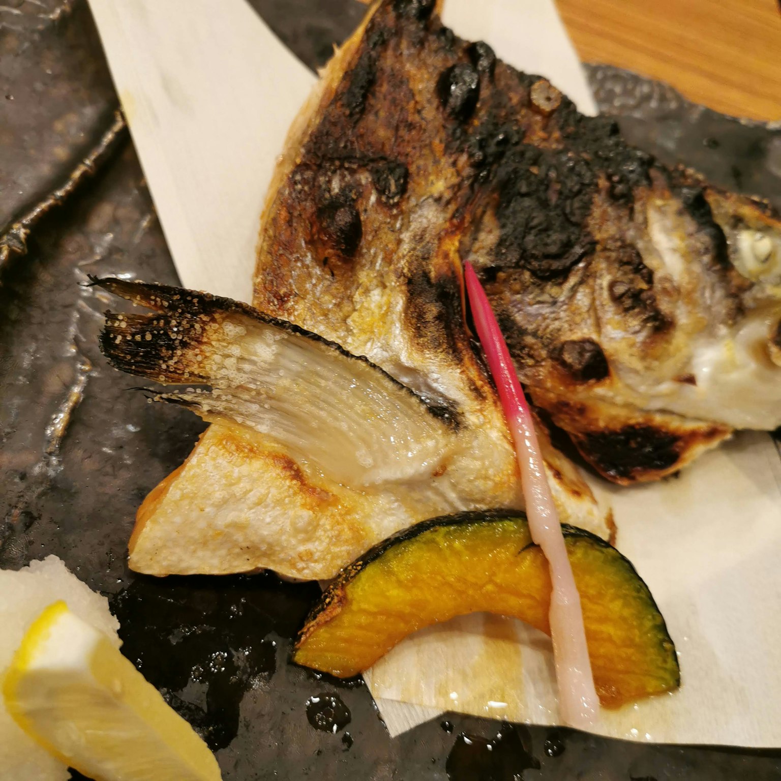 烤魚菜餚搭配檸檬和蔬菜