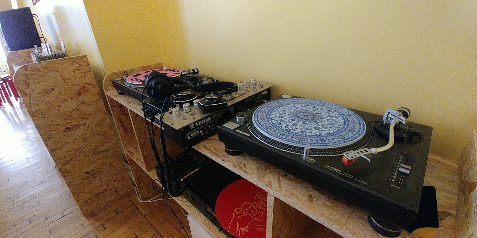 木制架子上的蓝色装饰转盘，旁边有DJ设备
