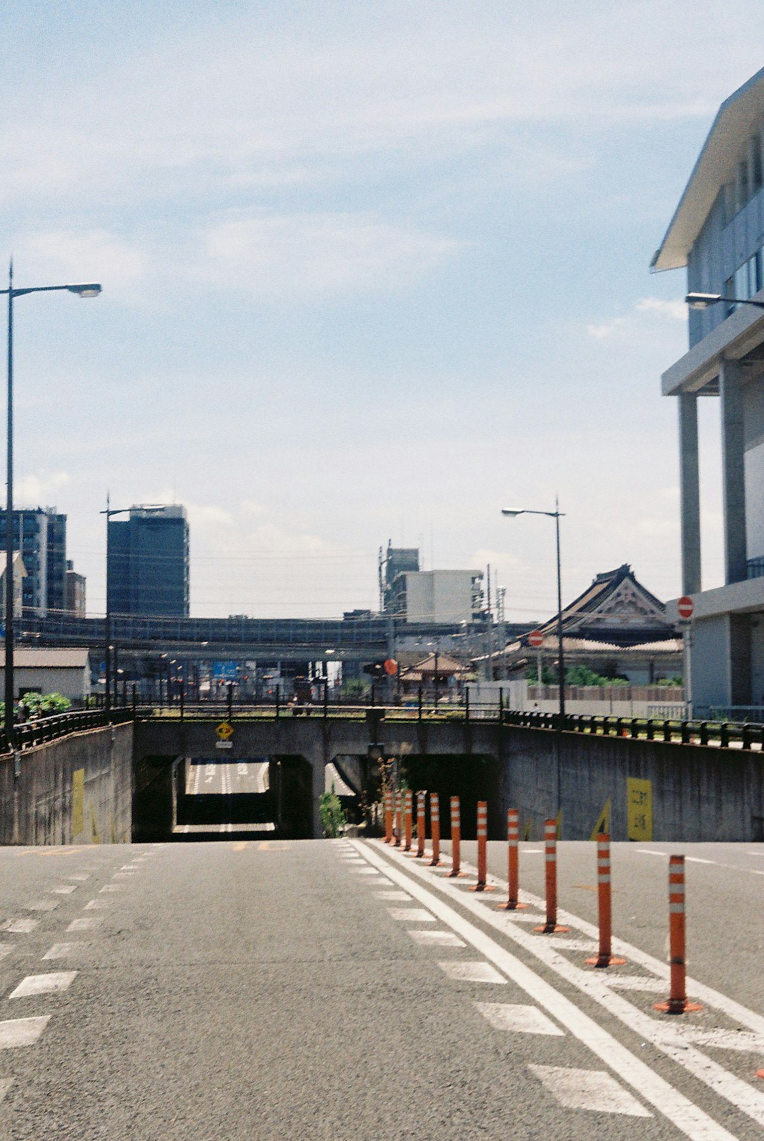 Jalan perkotaan dengan pemandangan jembatan layang bangunan dan langit biru terlihat