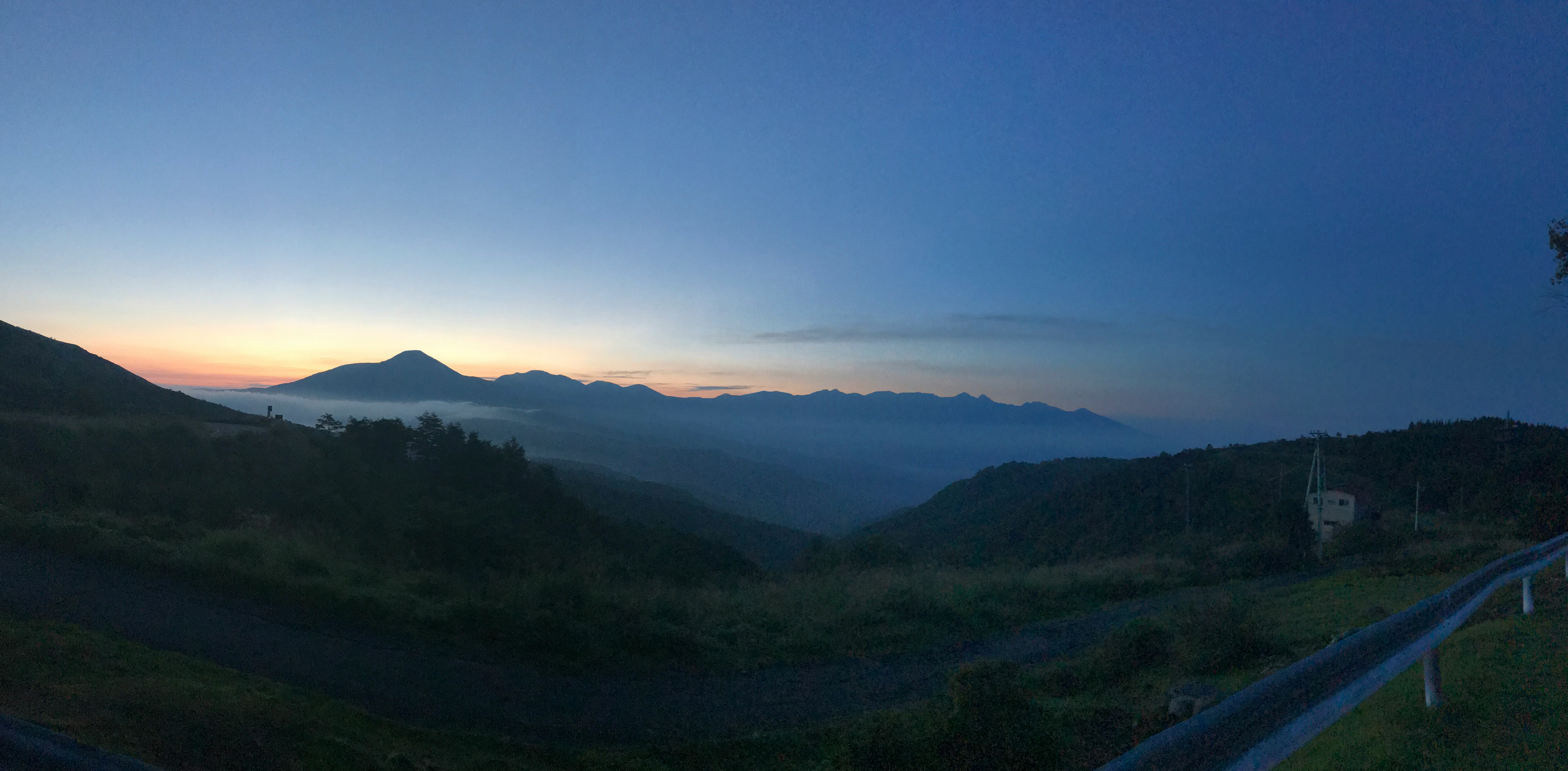 Blick auf Bergkämme bei Dämmerung von einem Hügel aus