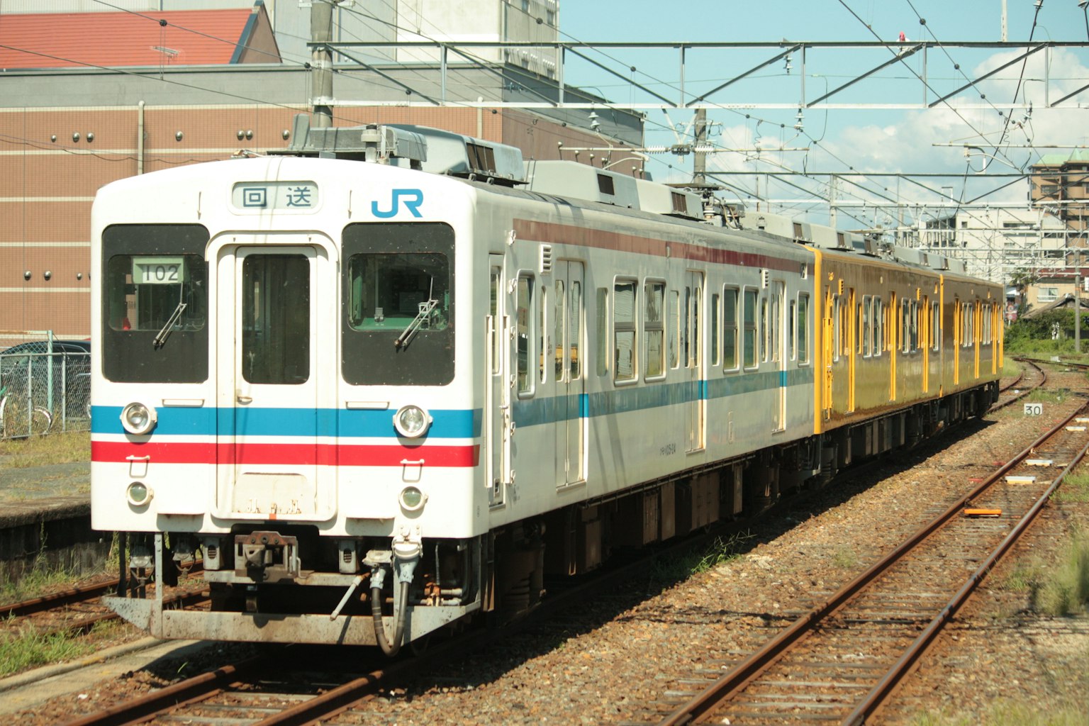 White and yellow train stopped on the tracks