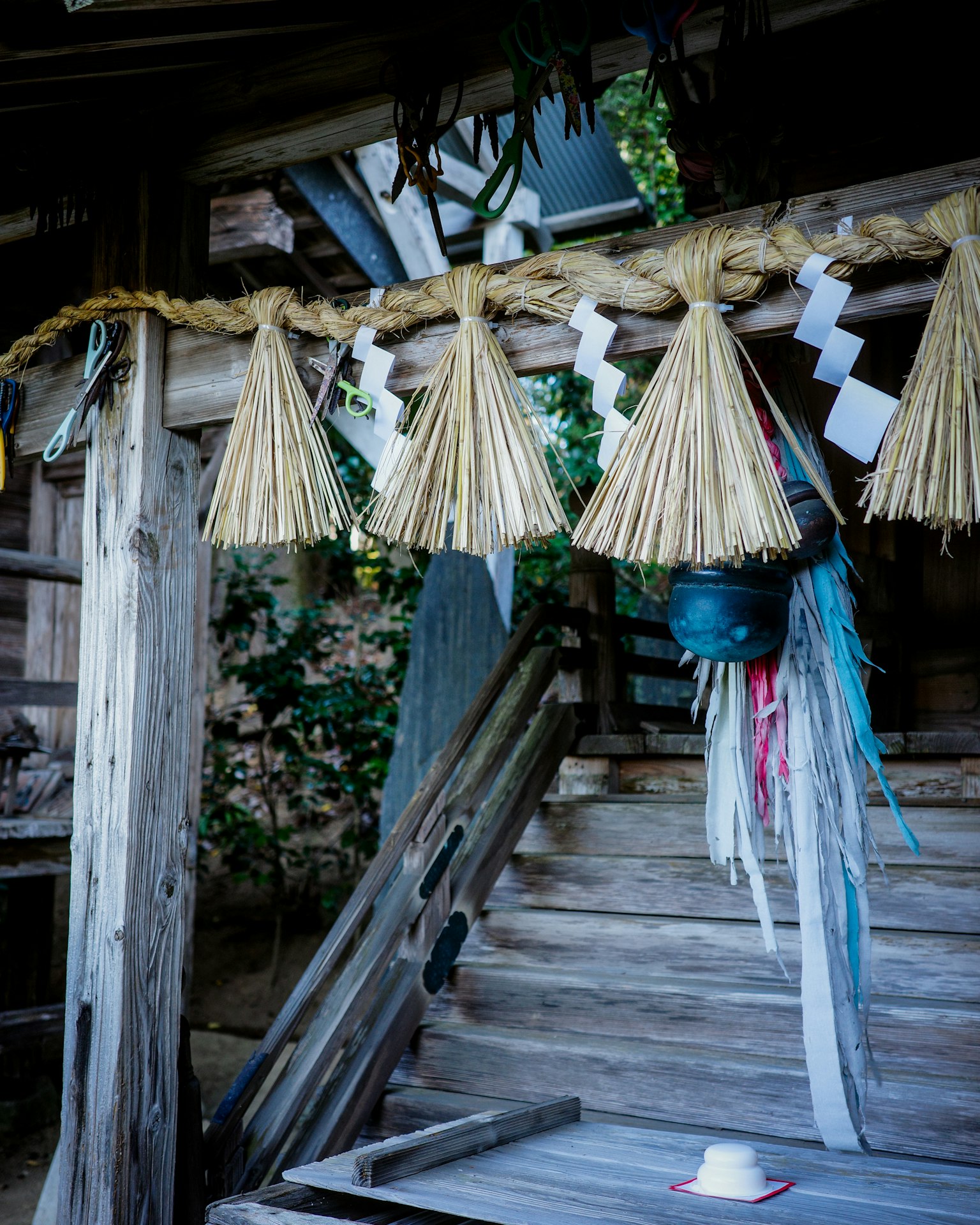 Décor traditionnel japonais suspendu à une entrée en bois avec des ornements en paille et des rubans colorés