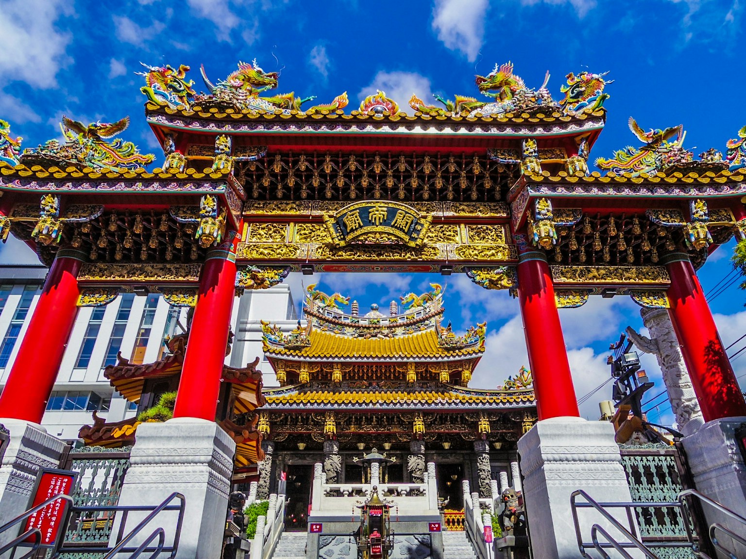 Arcade colorée d'un temple chinois avec des piliers rouges et des décorations dorées