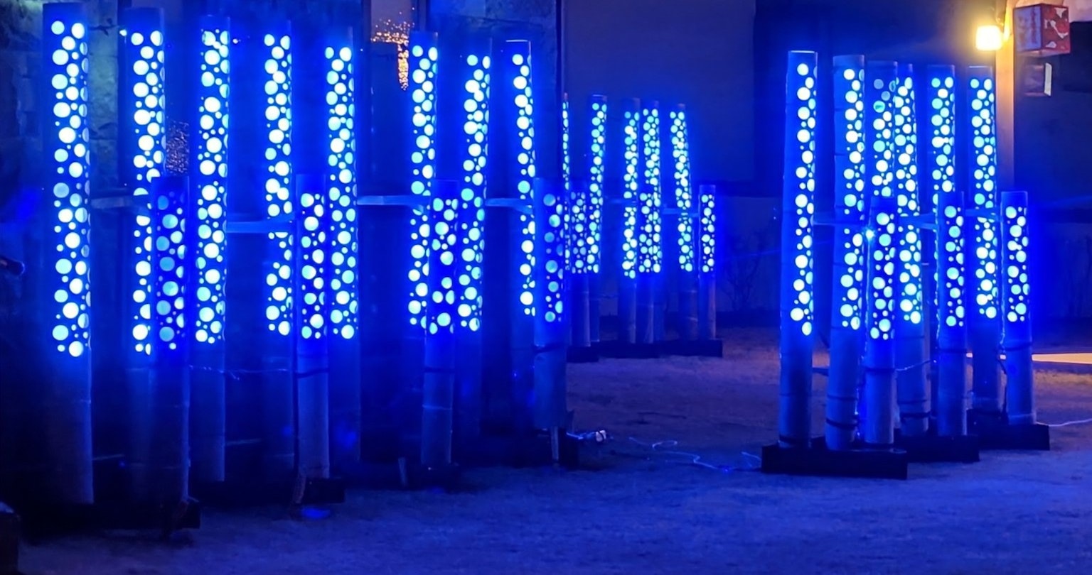 A row of illuminated blue columns in a nighttime setting
