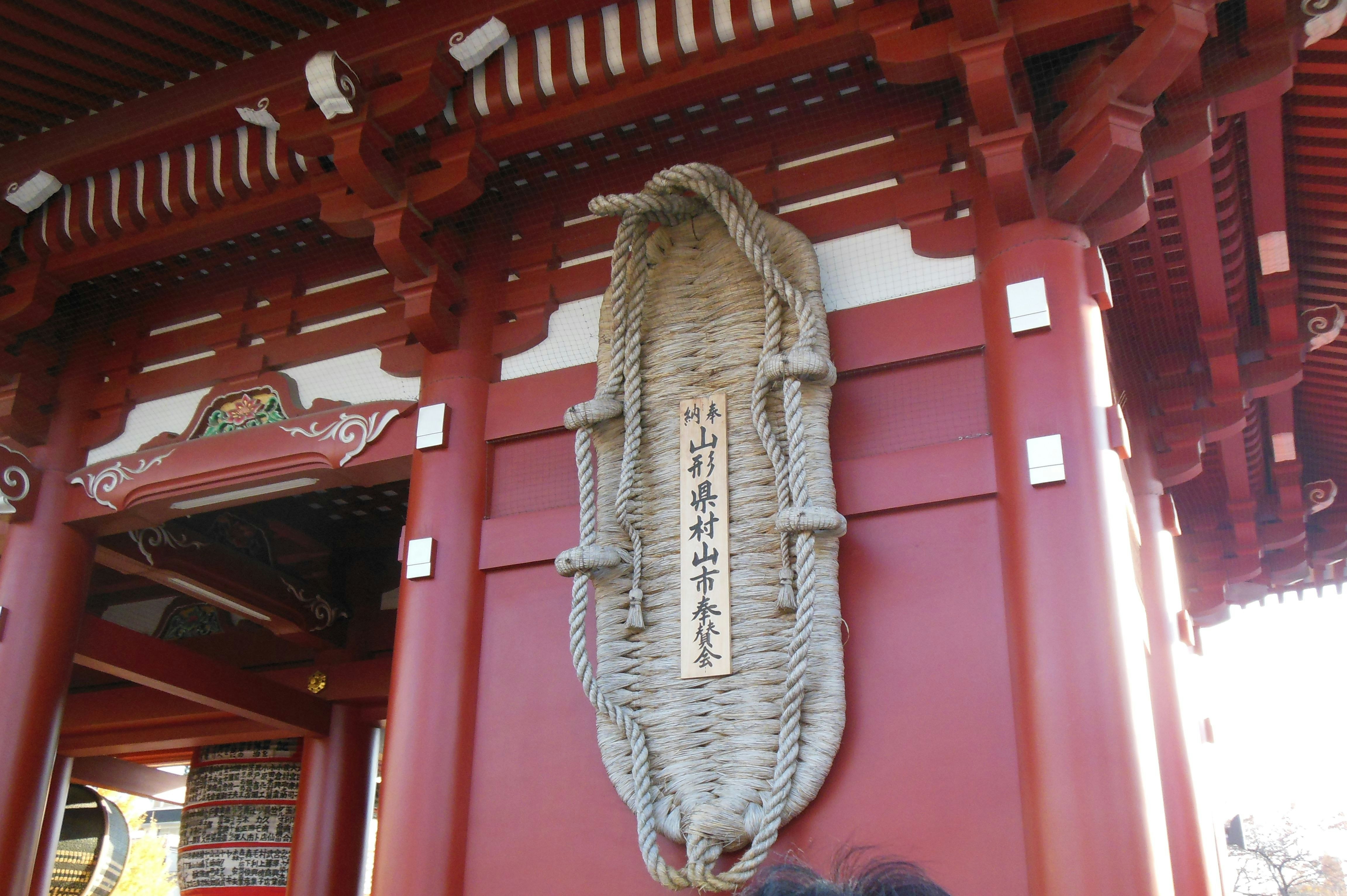 赤い社殿の軒下に下がる注連縄（しめなわ）