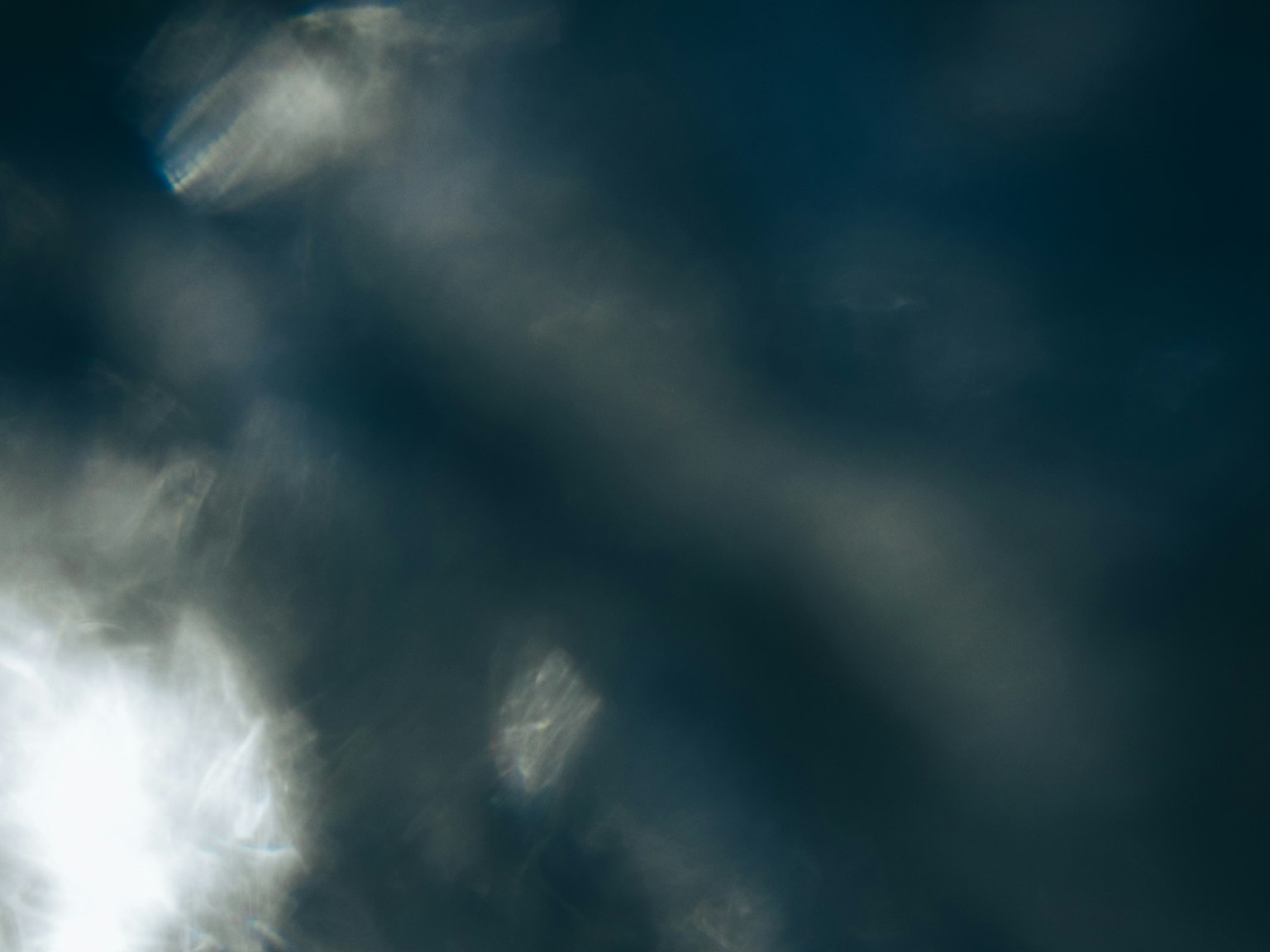 Riflessioni di luce e schemi nuvolosi su uno sfondo scuro