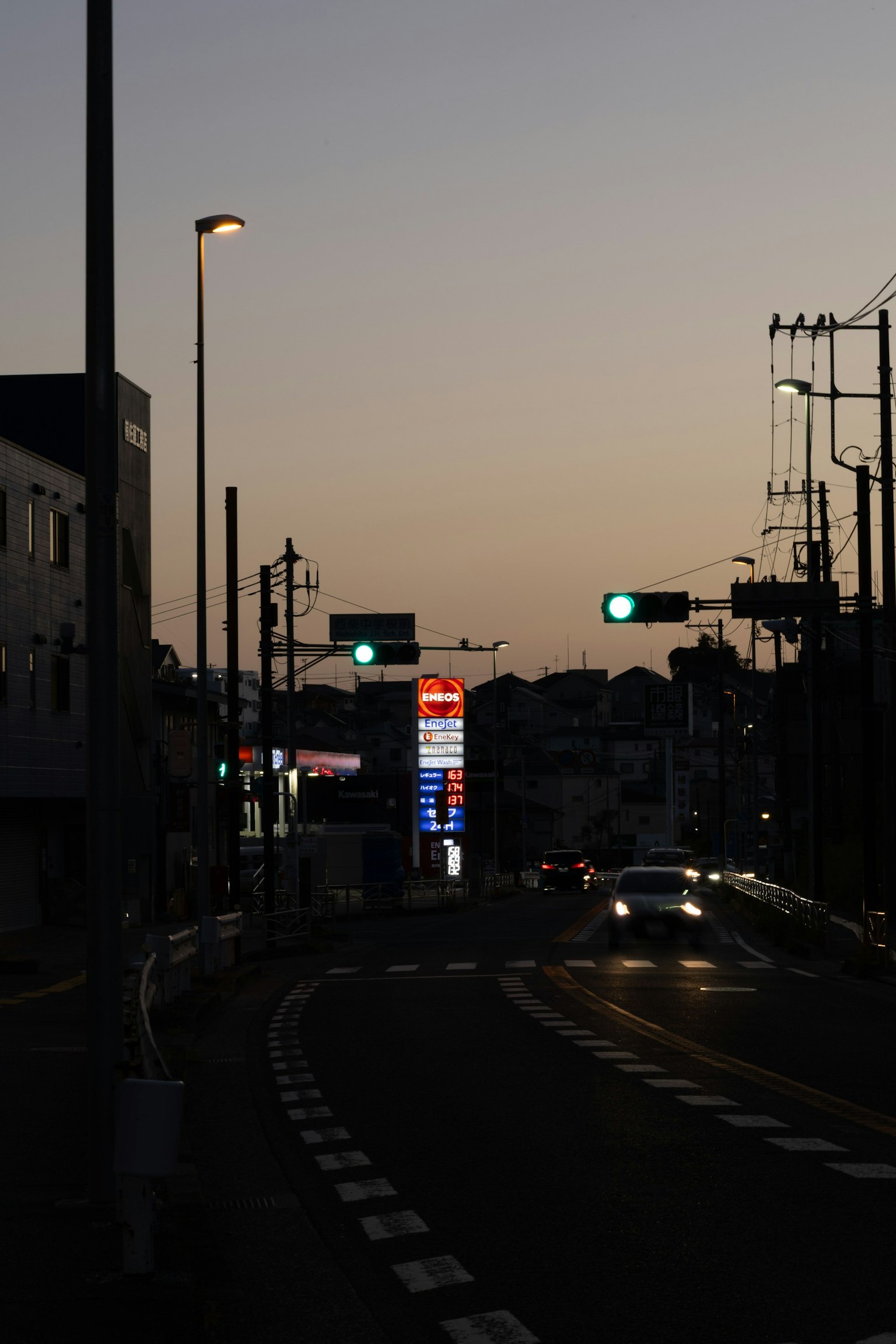 Scène de rue au crépuscule avec feux de circulation et lampadaires