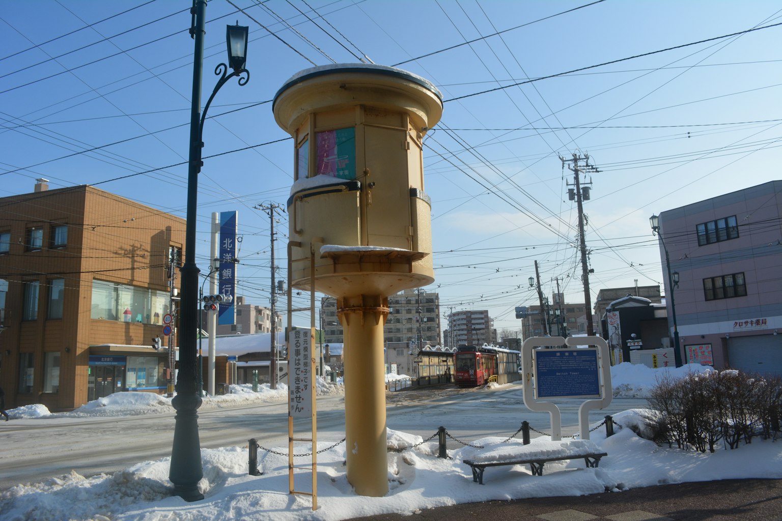 雪覆盖的街角上的黄色电话亭和周围建筑