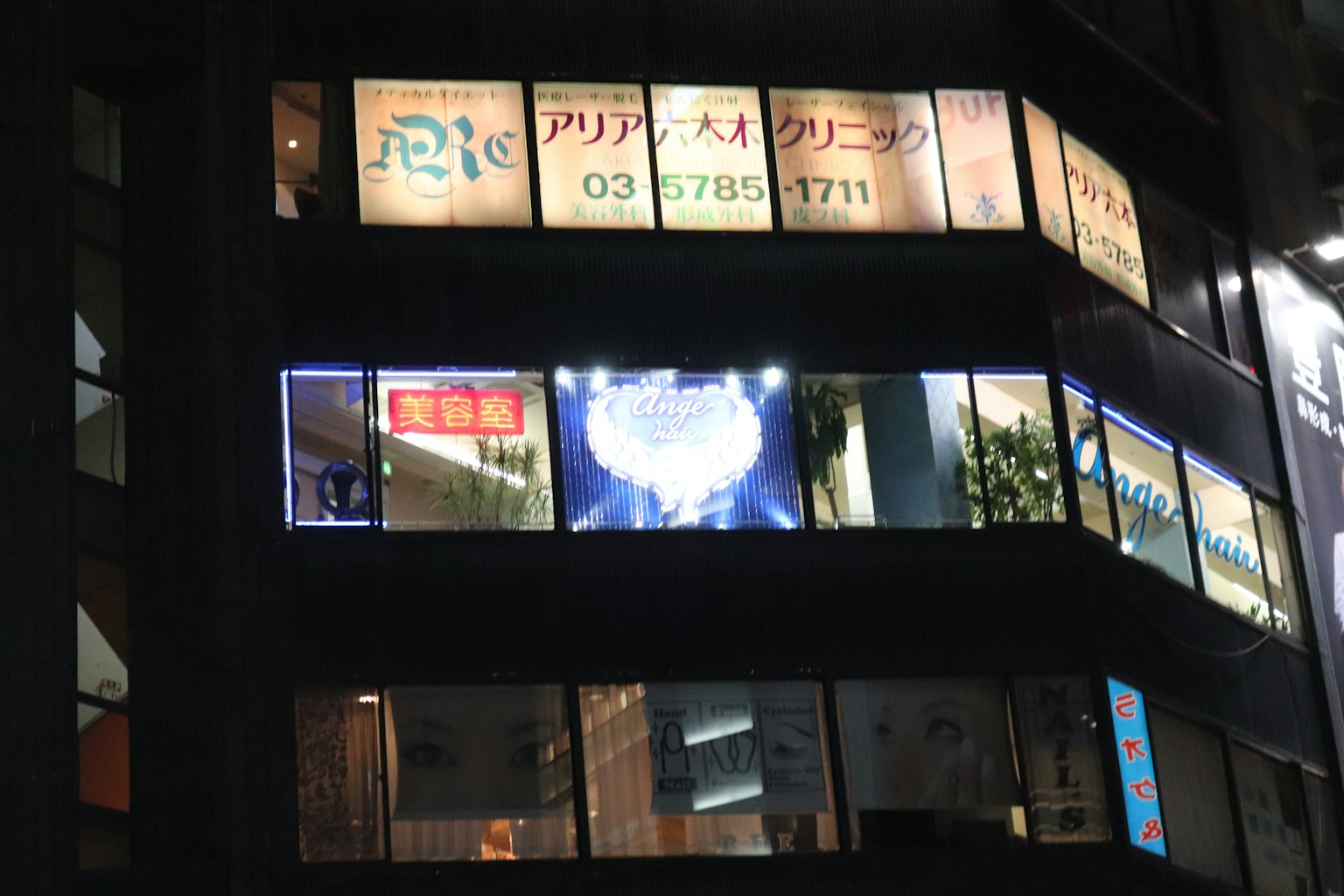 Biển hiệu sáng và ánh sáng trên cửa sổ tòa nhà vào ban đêm