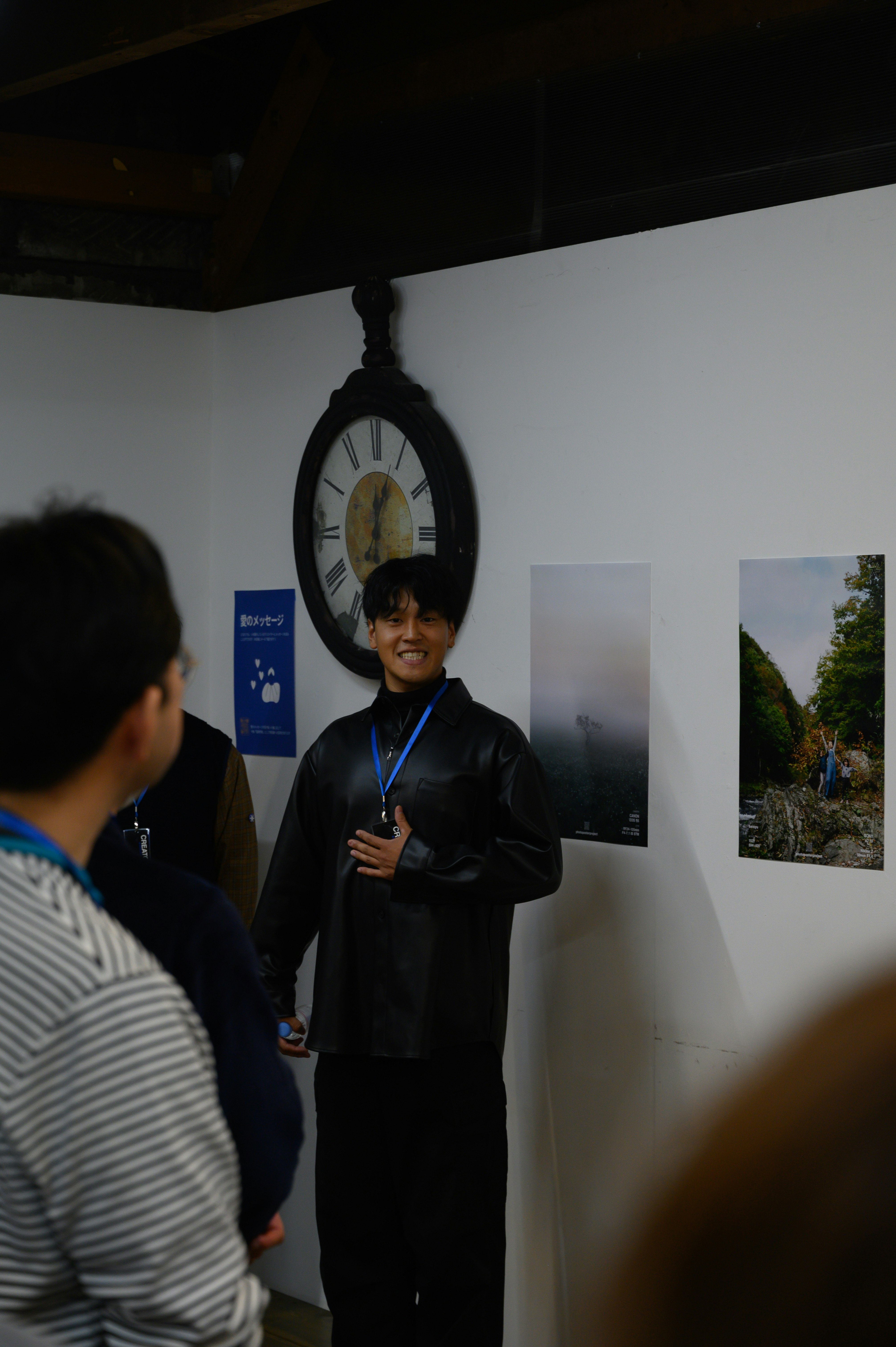 展示会場で表彰を受ける人物と壁面の写真パネル