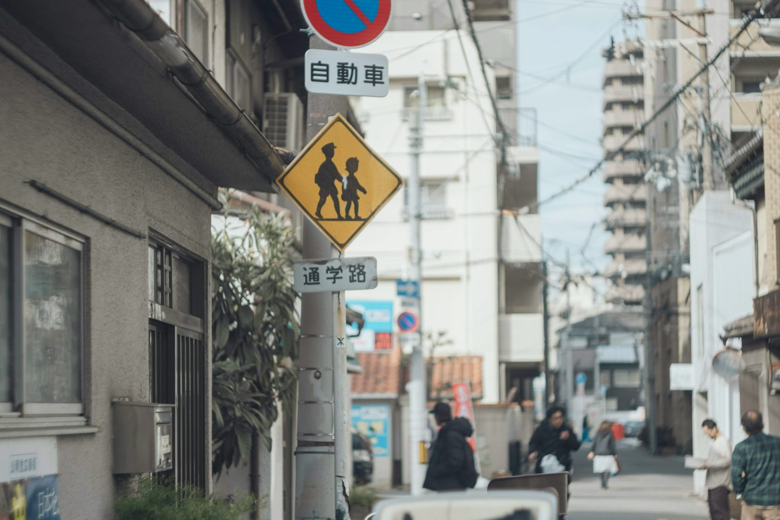 Straßeneckansicht mit Fußgängern und einem Kinderschild
