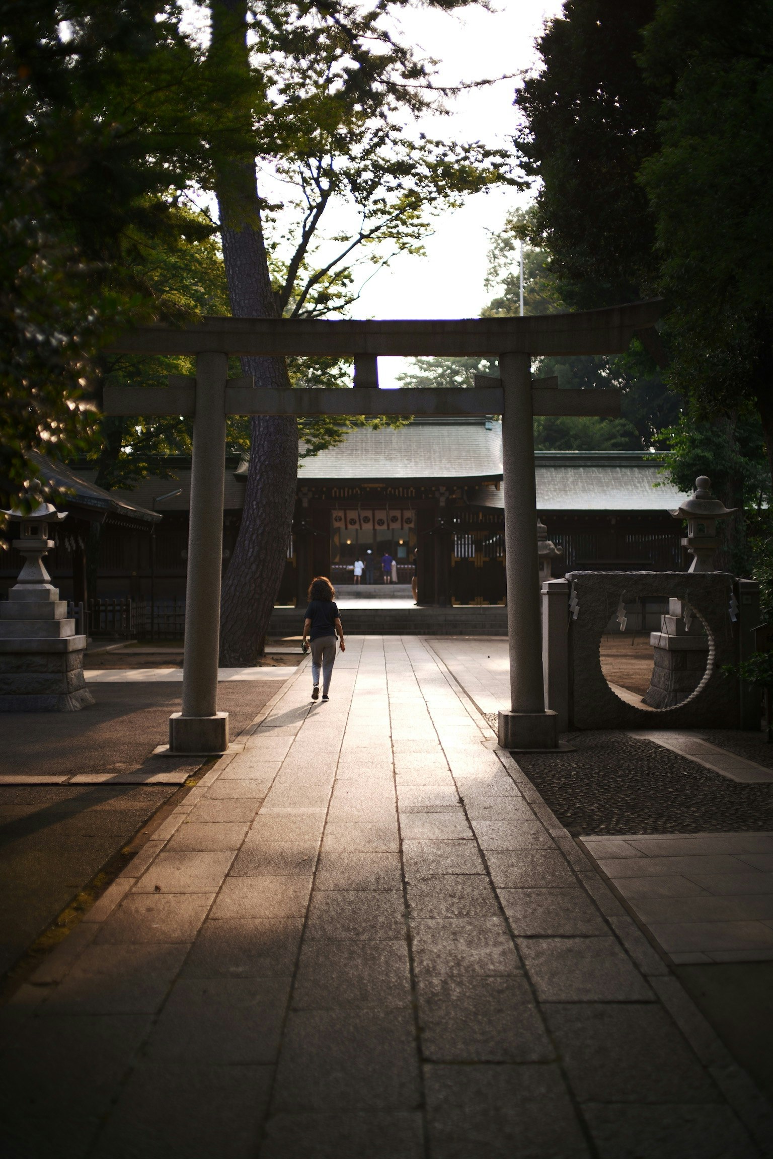 神社の鳥居を通り抜ける人影と静かな道