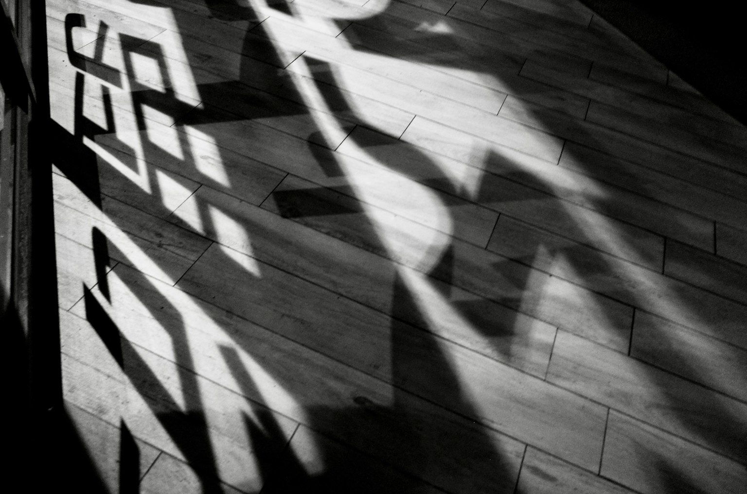 Imagen en blanco y negro que muestra sombras proyectadas en el suelo
