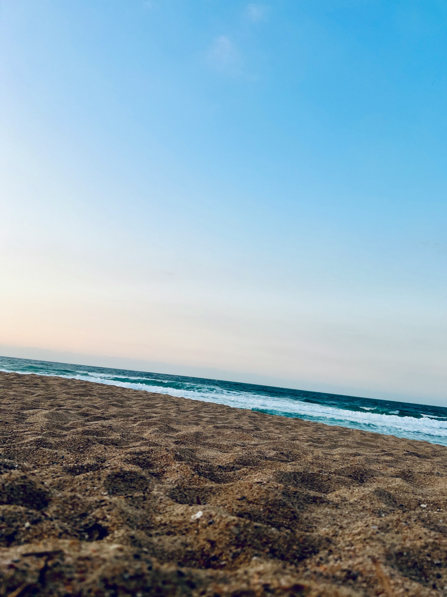 Scène de plage avec du sable et des vagues de l'océan sous un ciel bleu