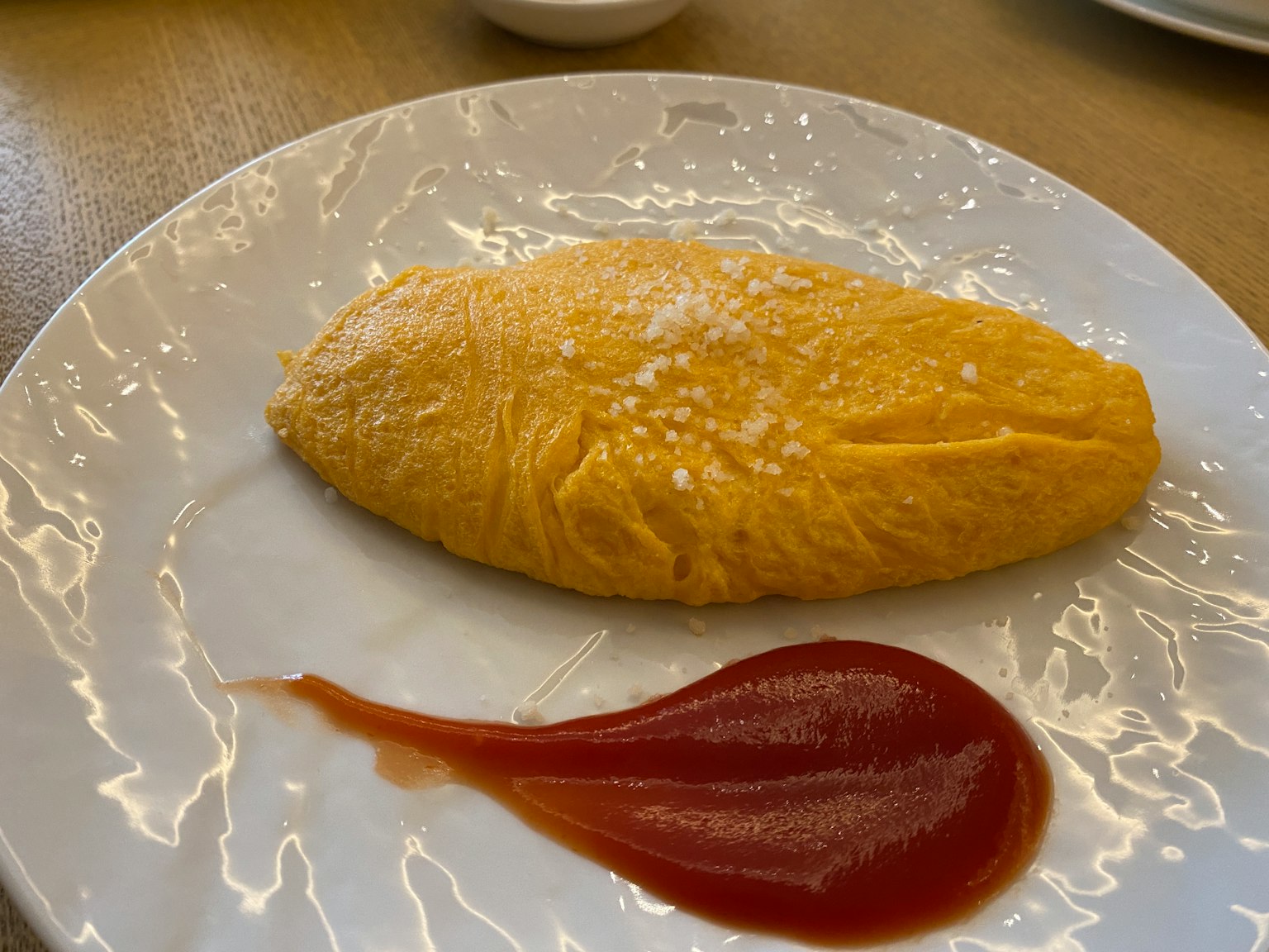 Plato con una tortilla esponjosa y un chorrito de ketchup