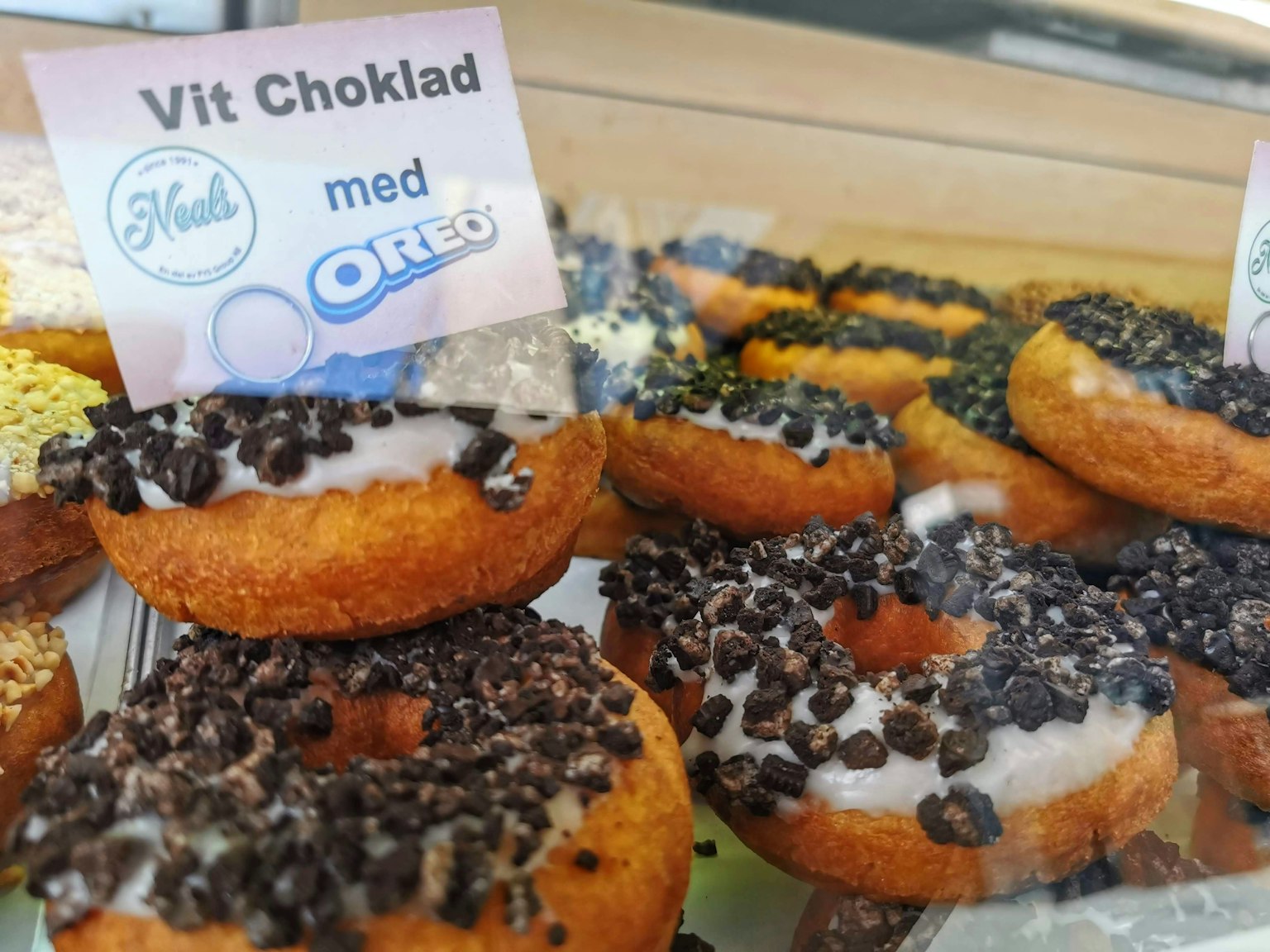 Esposizione di ciambelle guarnite con Oreos e crema al cioccolato bianco