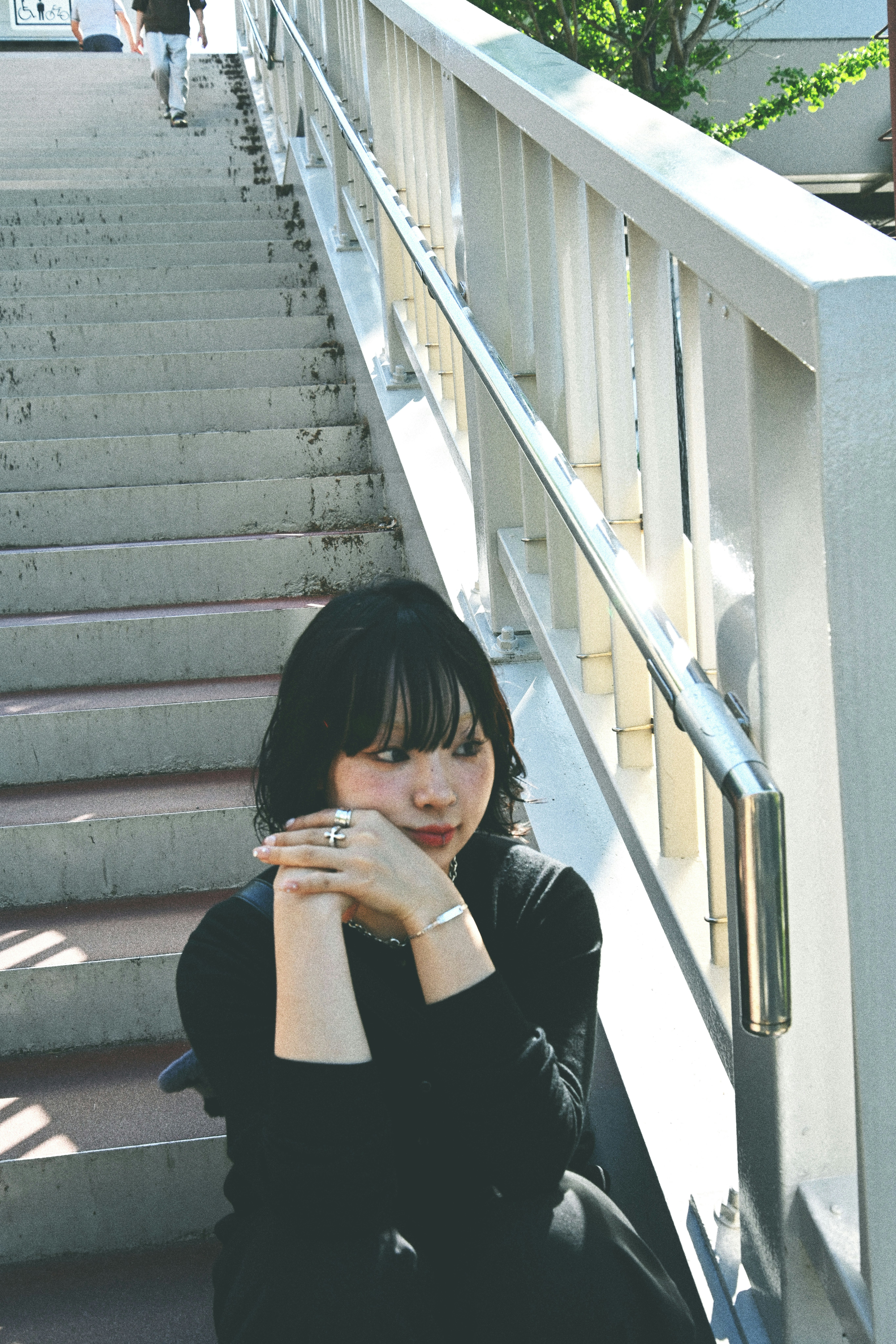 階段の踊り場で飲み物を飲む女性