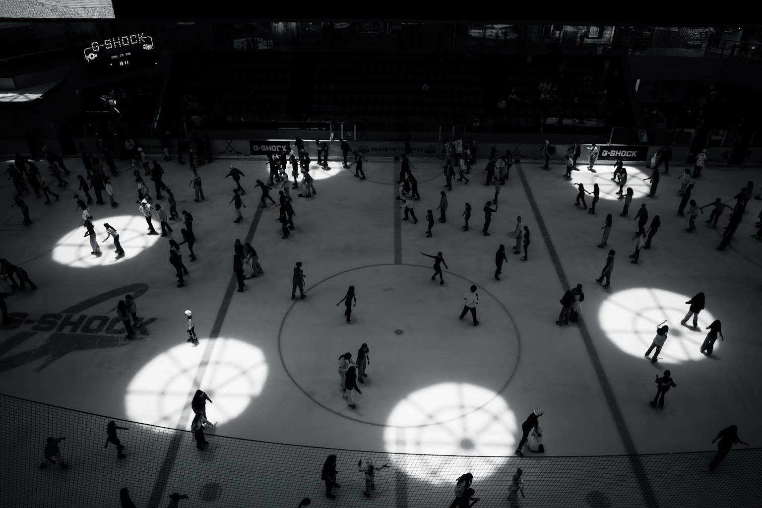 Multitud de personas patinando sobre hielo con patrones de luz circulares