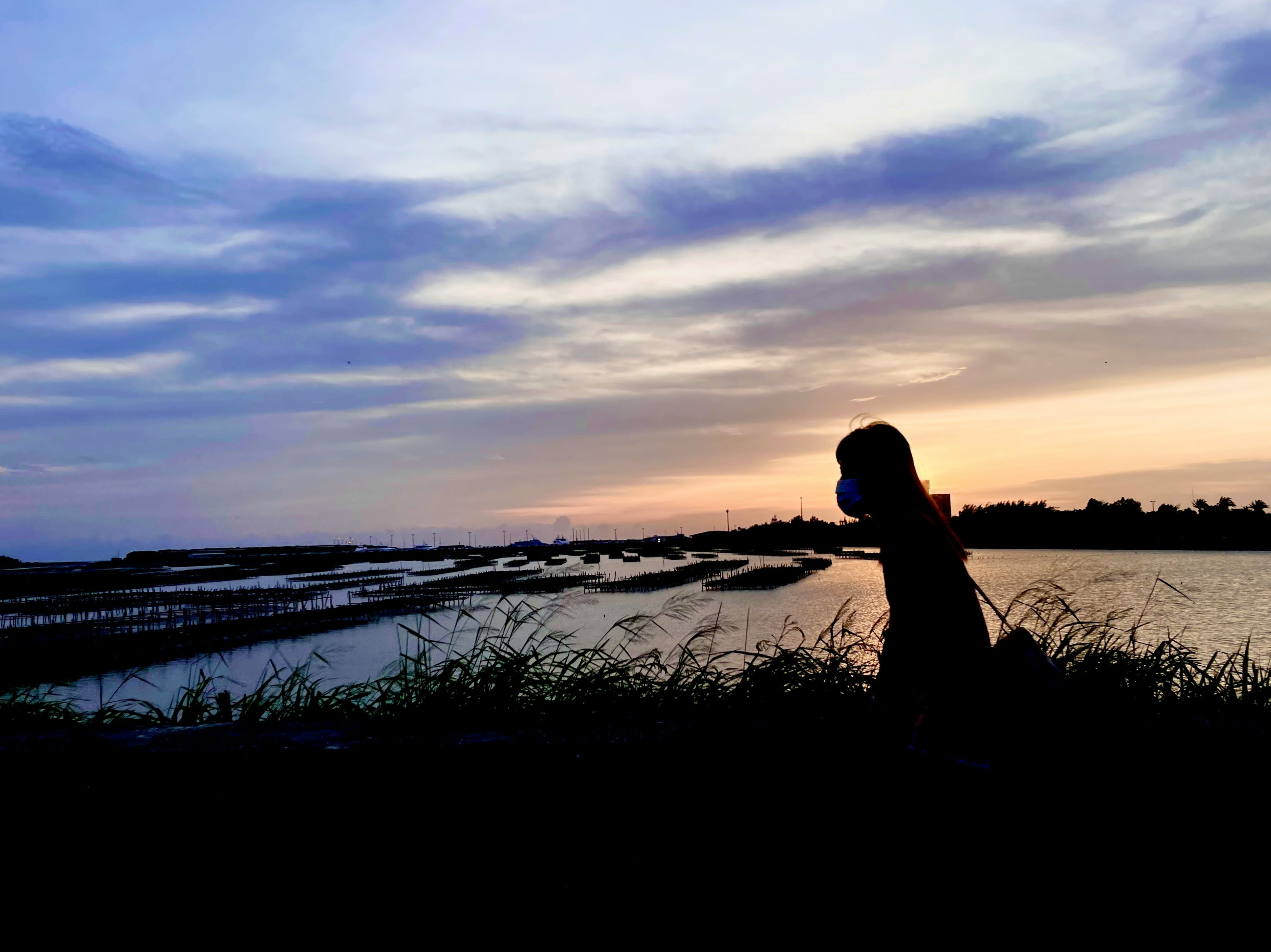 夕暮れの川辺でシルエットの人物