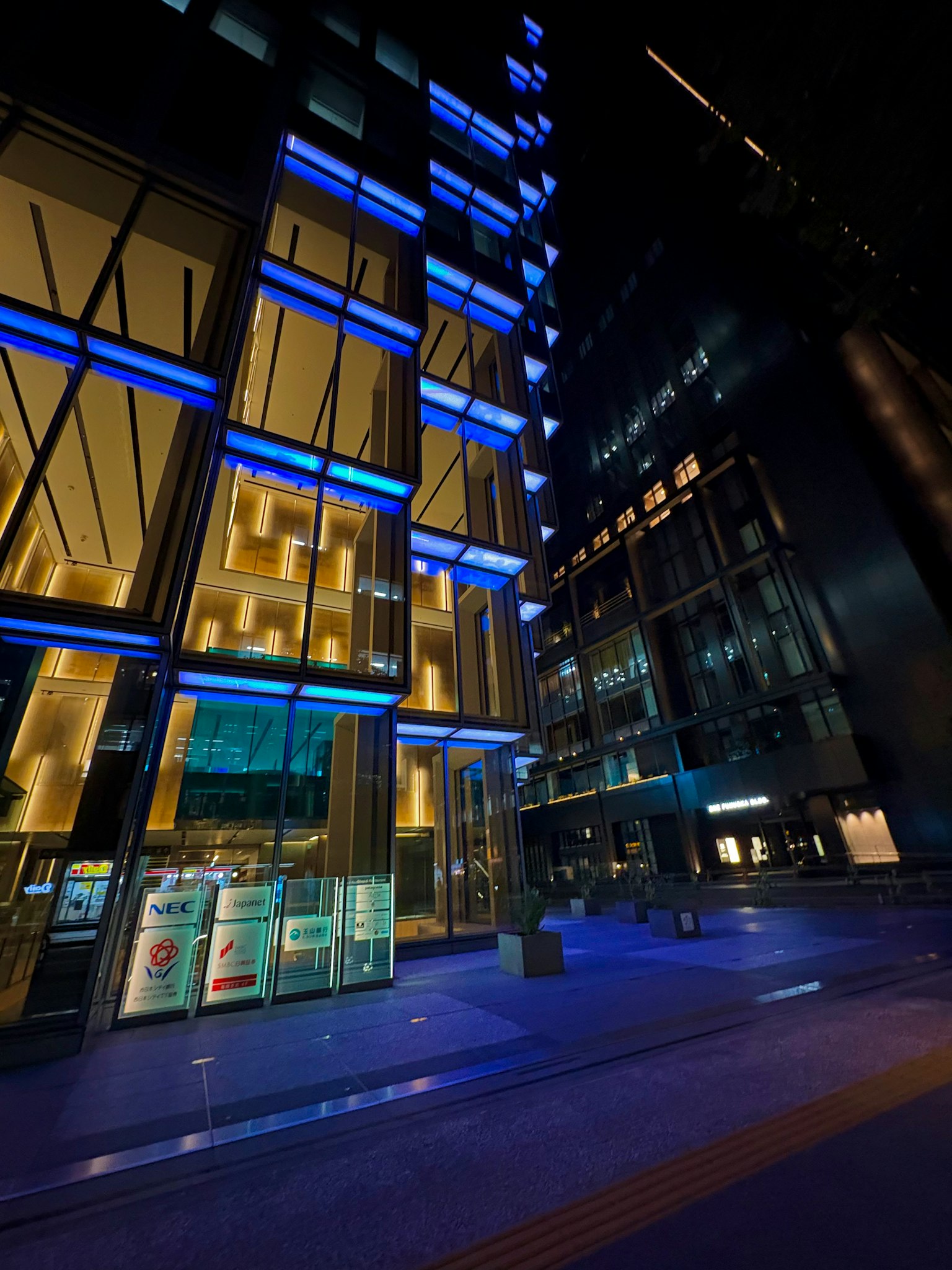 Paysage urbain nocturne avec des gratte-ciel illuminés en bleu et des façades en verre