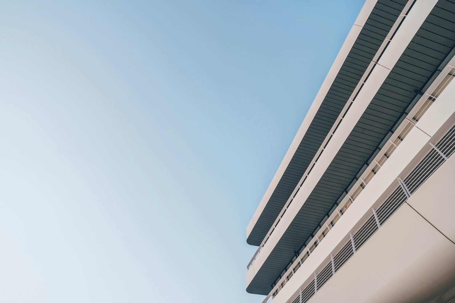 Bangunan modern di bawah langit biru cerah dengan garis ramping dan desain minimalis