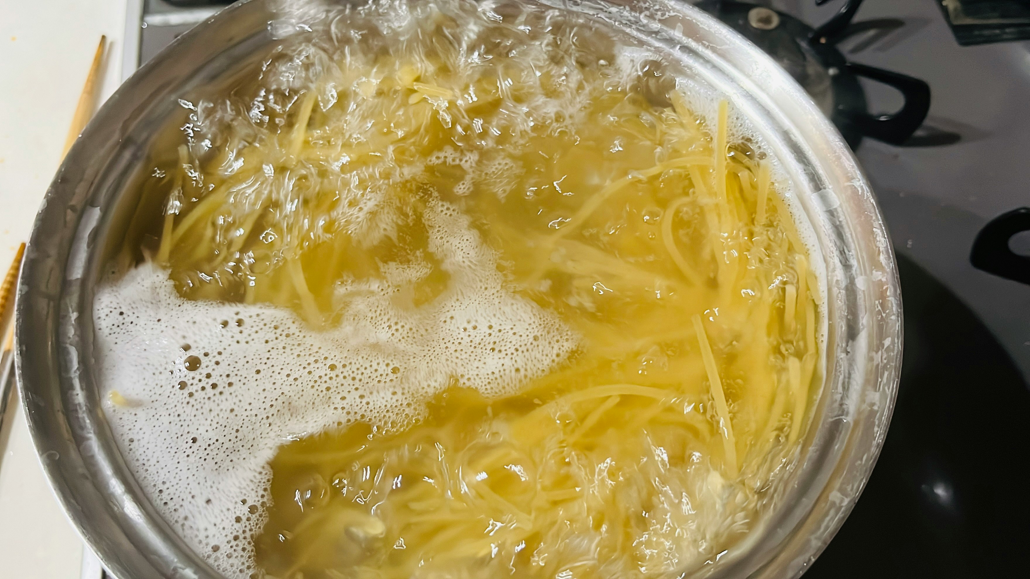 nouilles jaunes et soupe mousseuse dans un récipient transparent