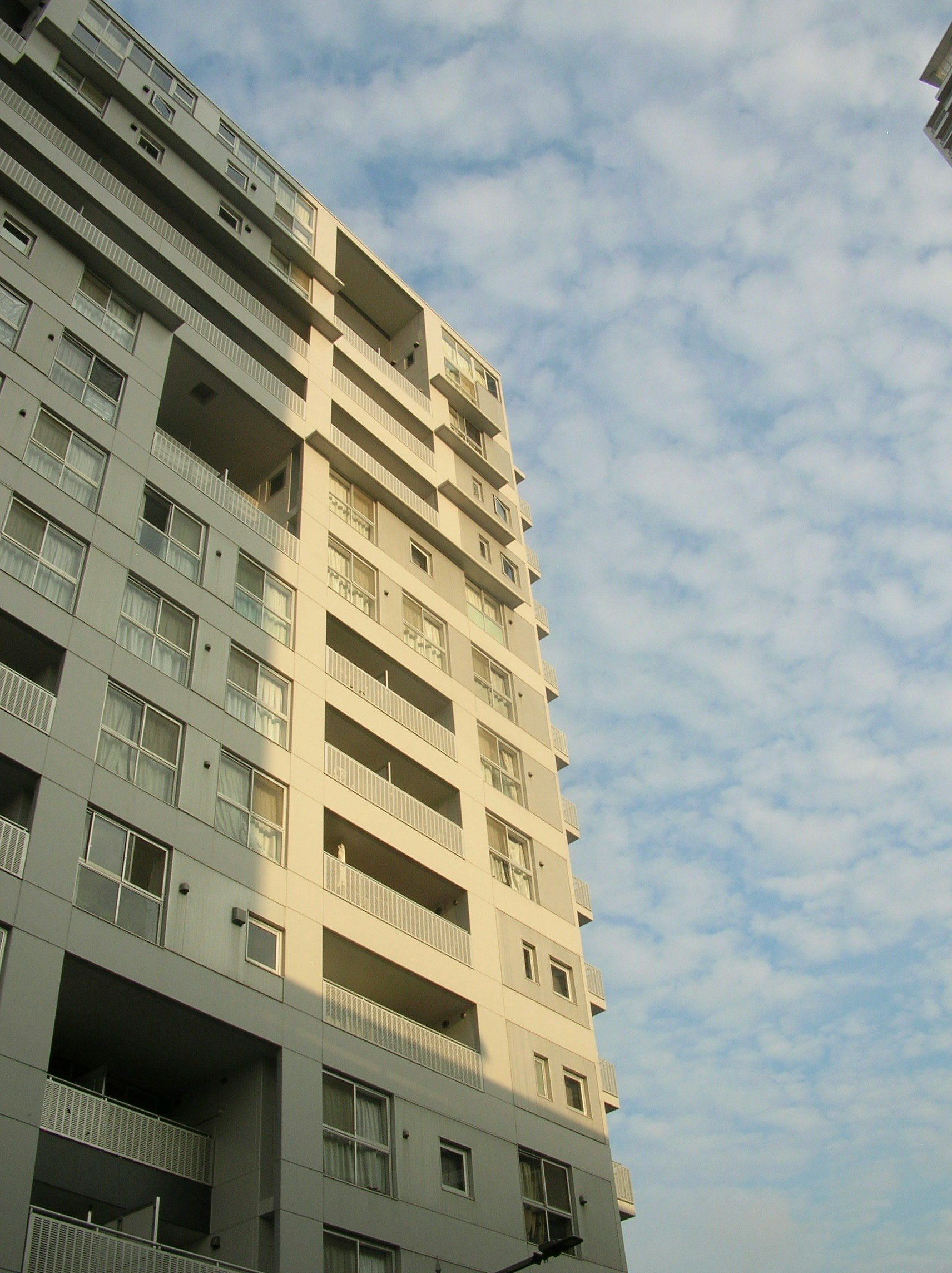 夏の空に面した高層マンションの外観