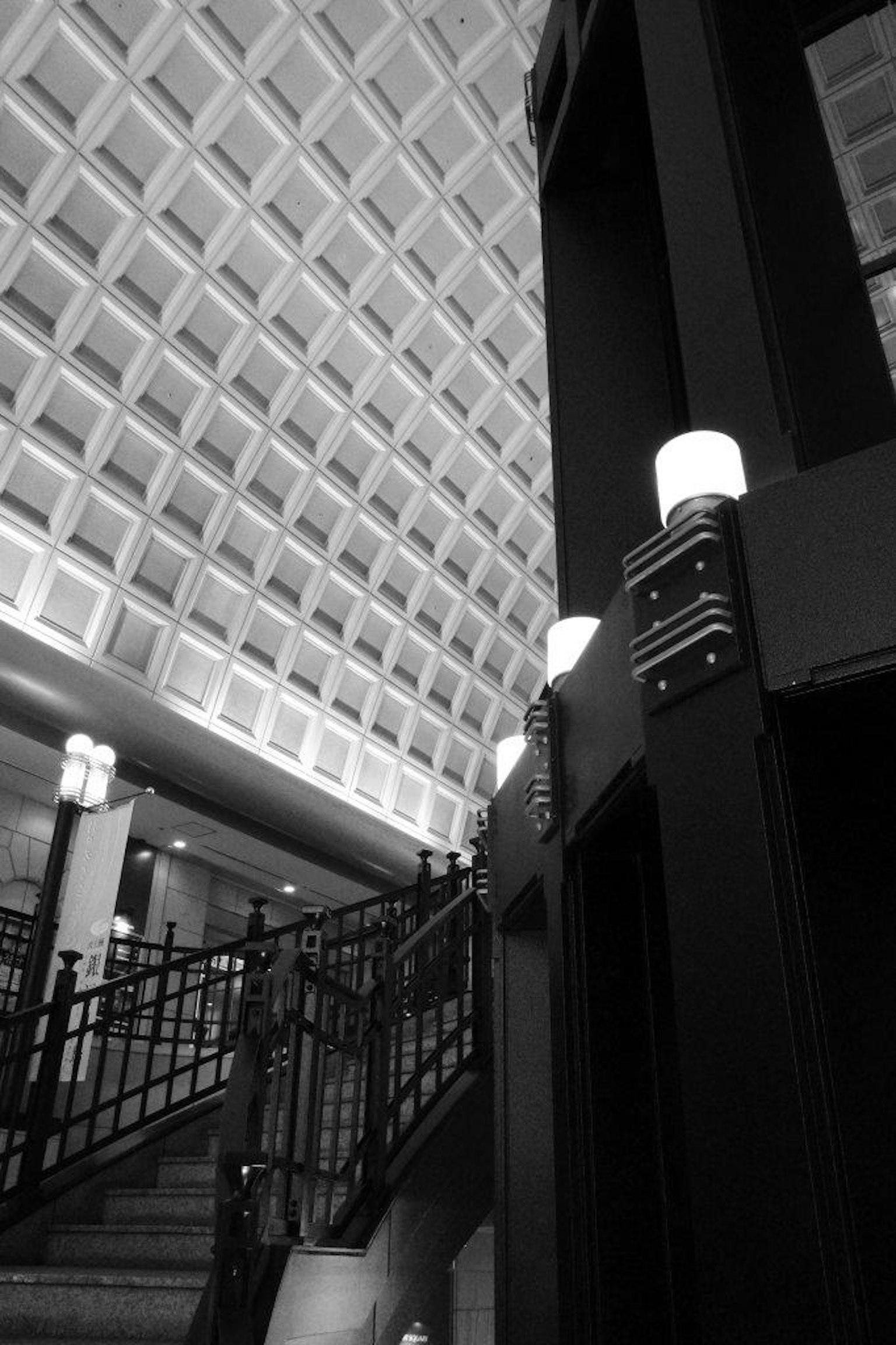 Tampilan interior bangunan modern yang menampilkan tangga dan lift