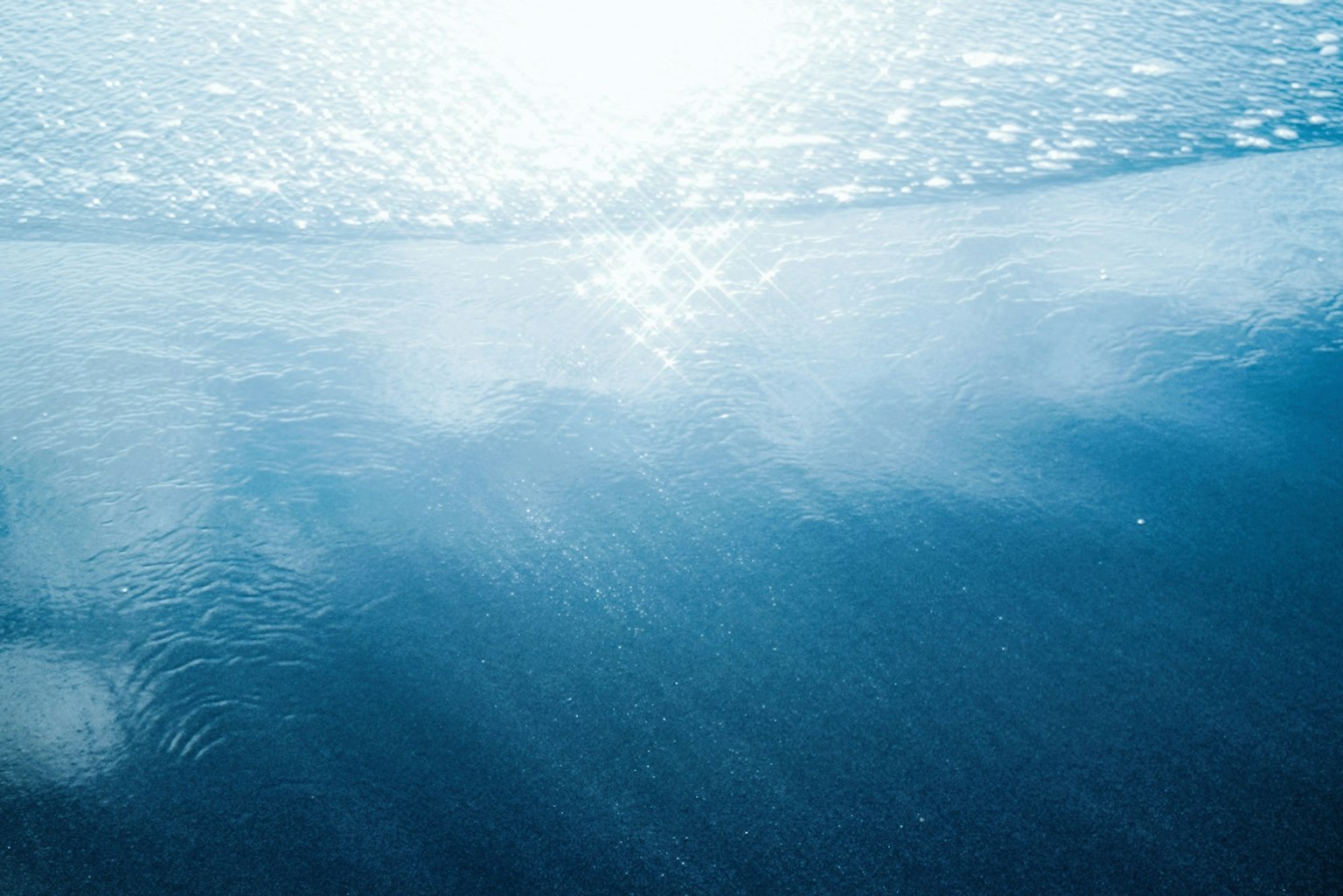 Calm water surface reflecting light with shades of blue