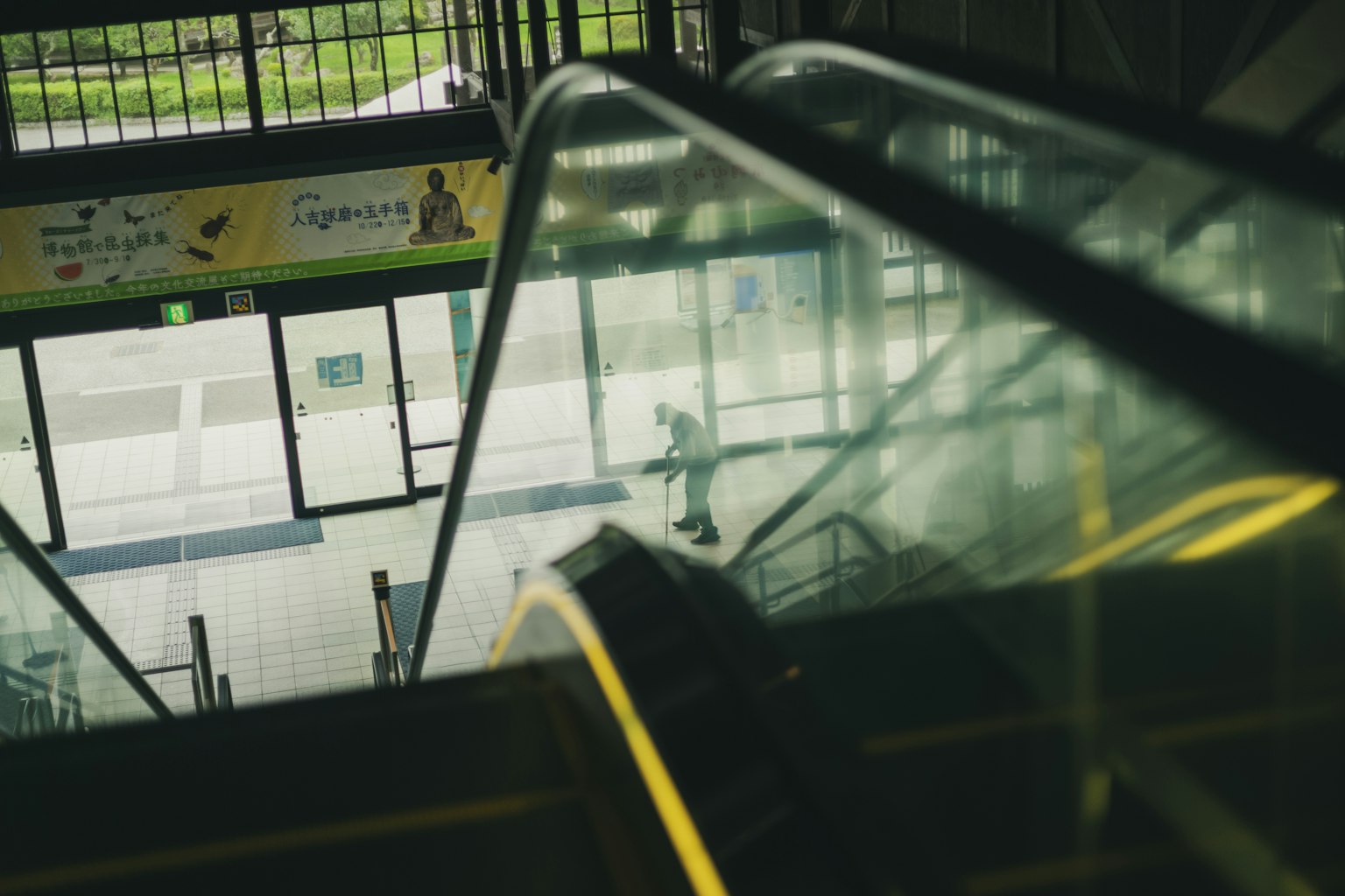 A person descending an escalator in a train station interior