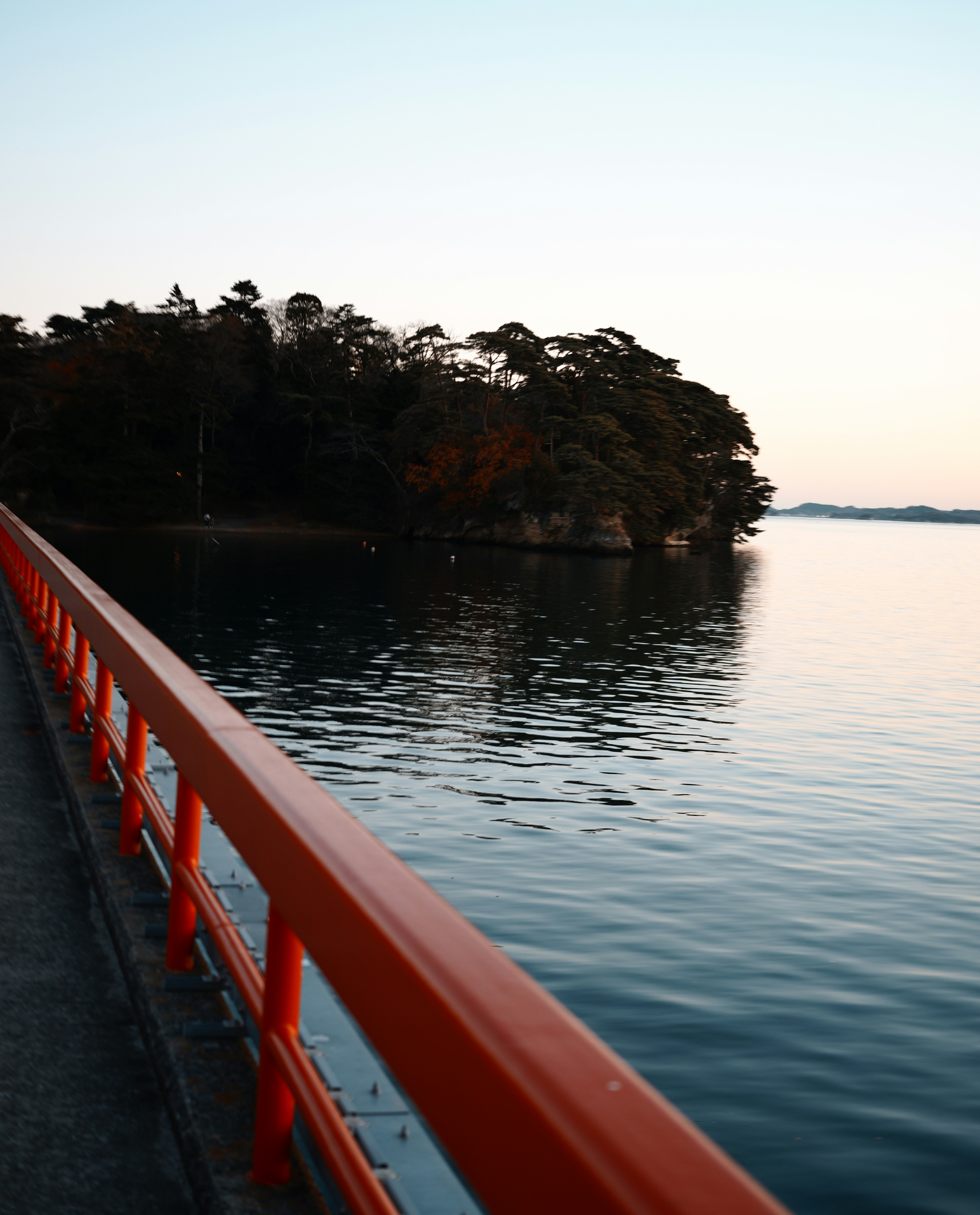 夕暮れの湖畔を走る赤い欄干の遊歩道