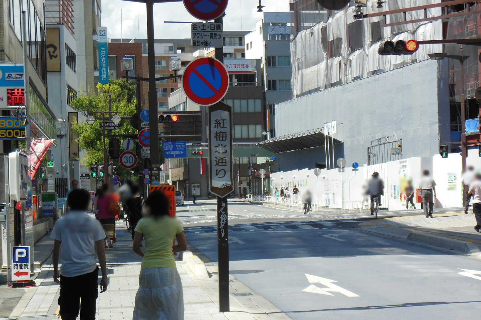 ถนนเมืองที่มีคนเดินและป้ายจราจร