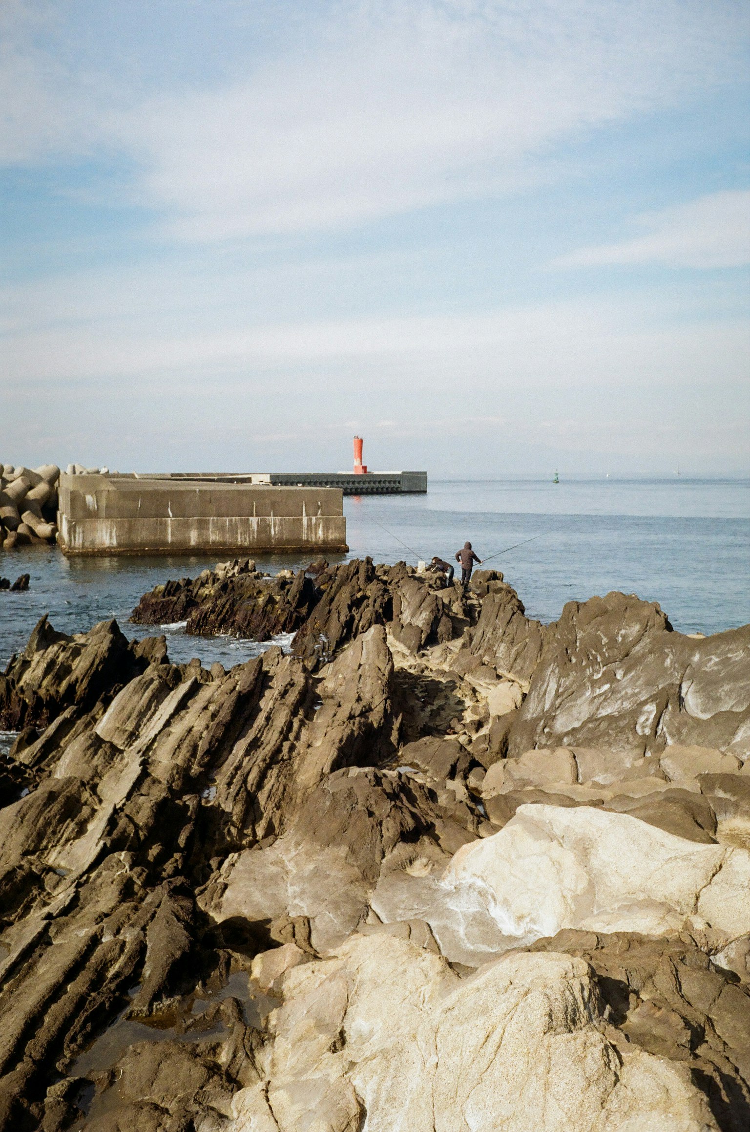 宁静的海景，岩石海岸线和远处可见的灯塔