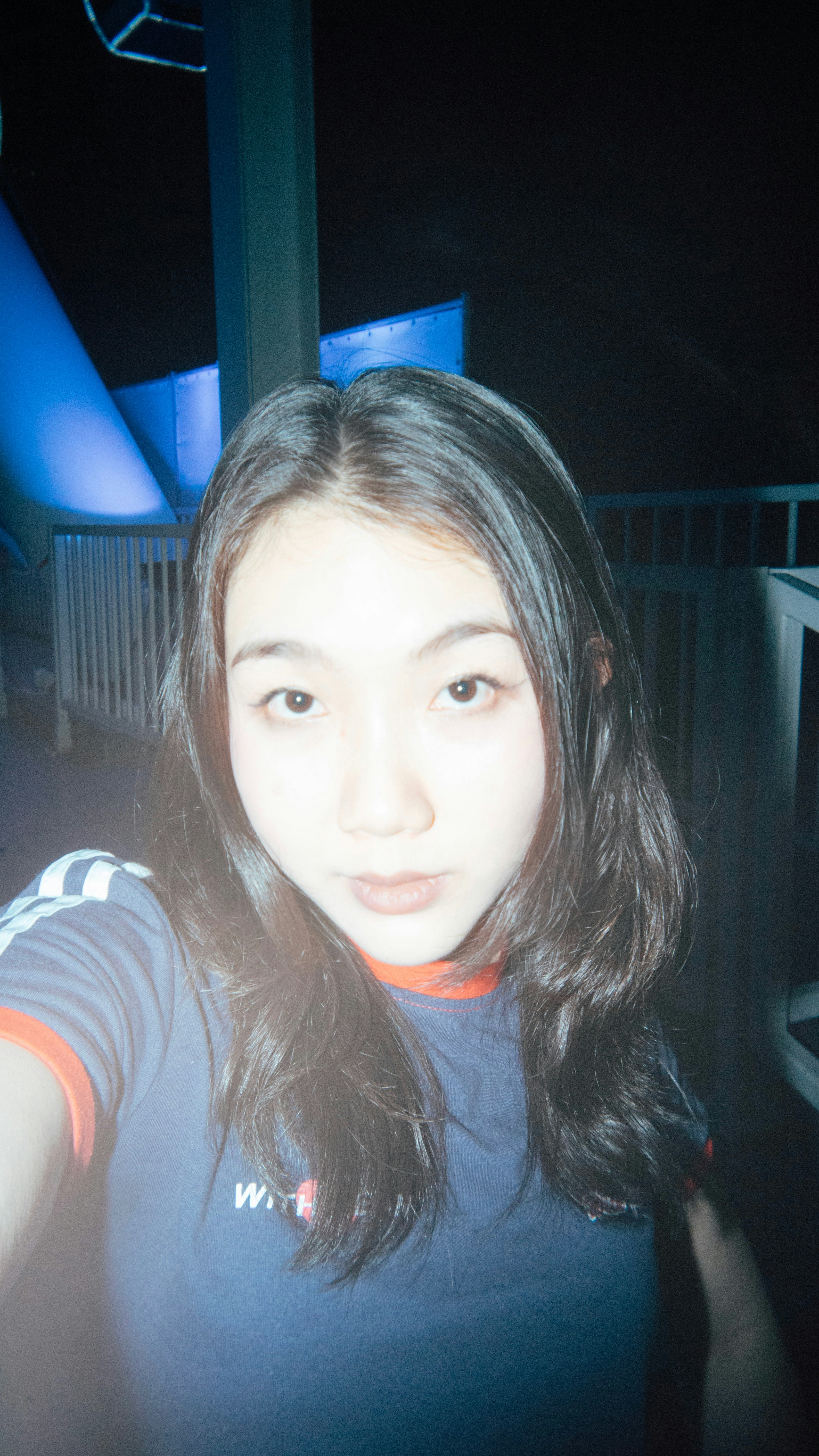 夜の屋外で自撮りする女性
