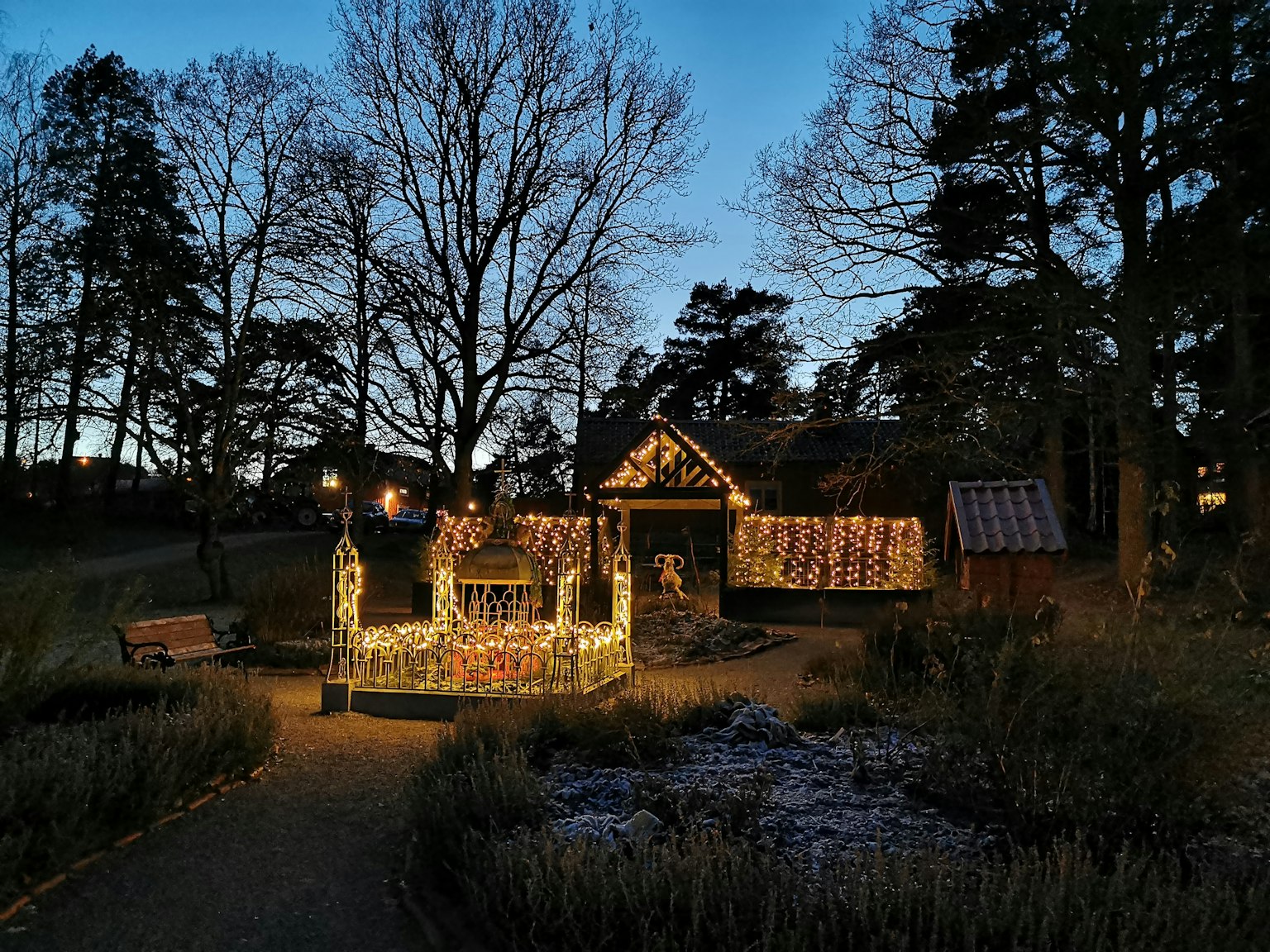 A nighttime scene featuring a small illuminated house and decorative buildings