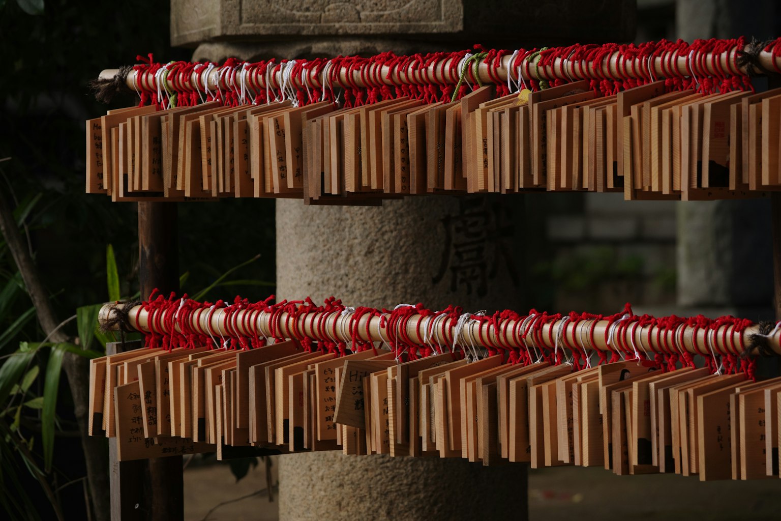 Placas ema de madera atadas con cuerdas rojas en un santuario