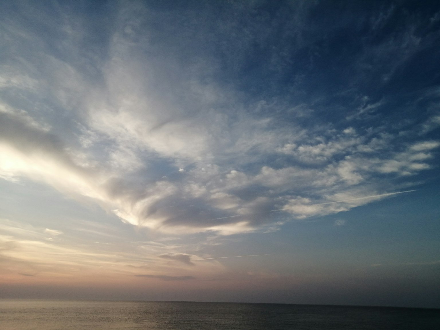 蓝天和云朵覆盖在宁静的海面上