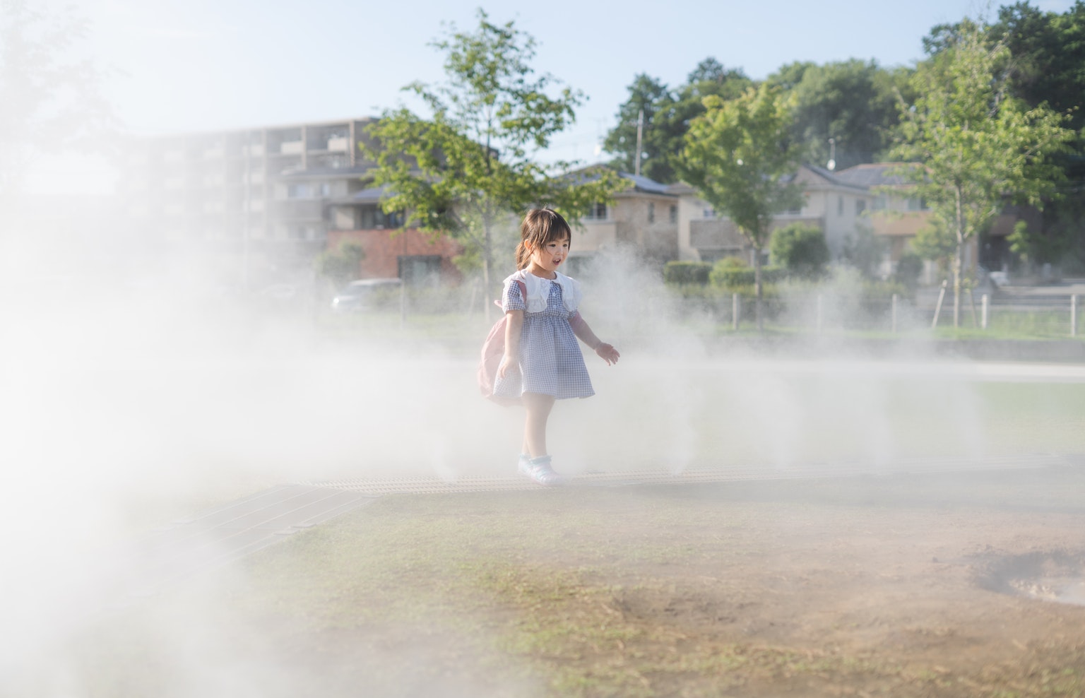 公園で霧の中を歩く女の子の写真
