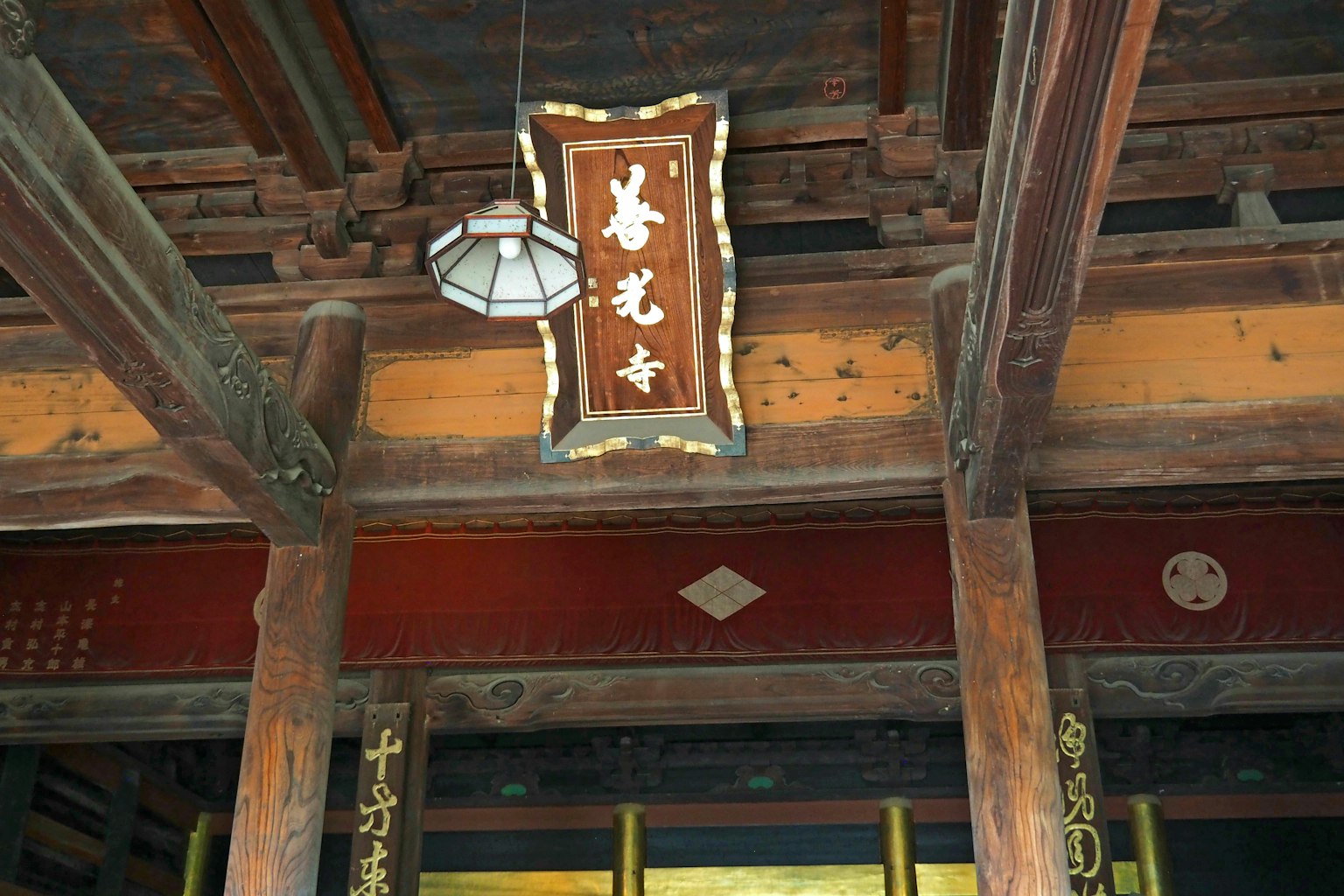 목조 사원 내부의 장식적인 간판과 천장 기둥