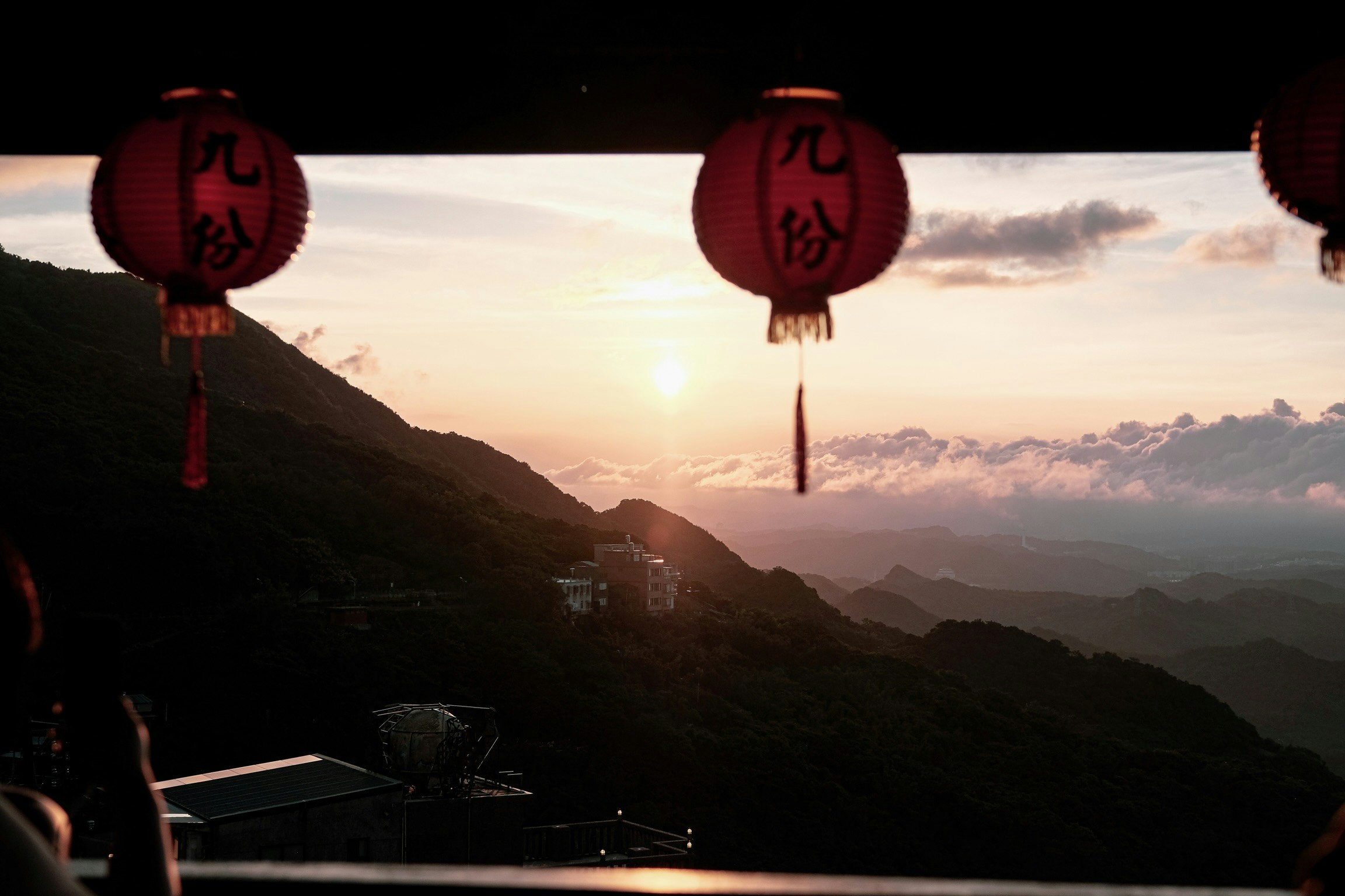 夕日に照らされた山並みと空に浮かぶ雲、九份の提灯のある展望