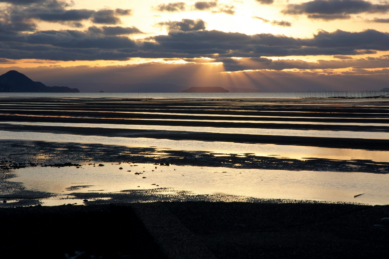 Coastal landscape with rays of light reflecting on tidal flats
