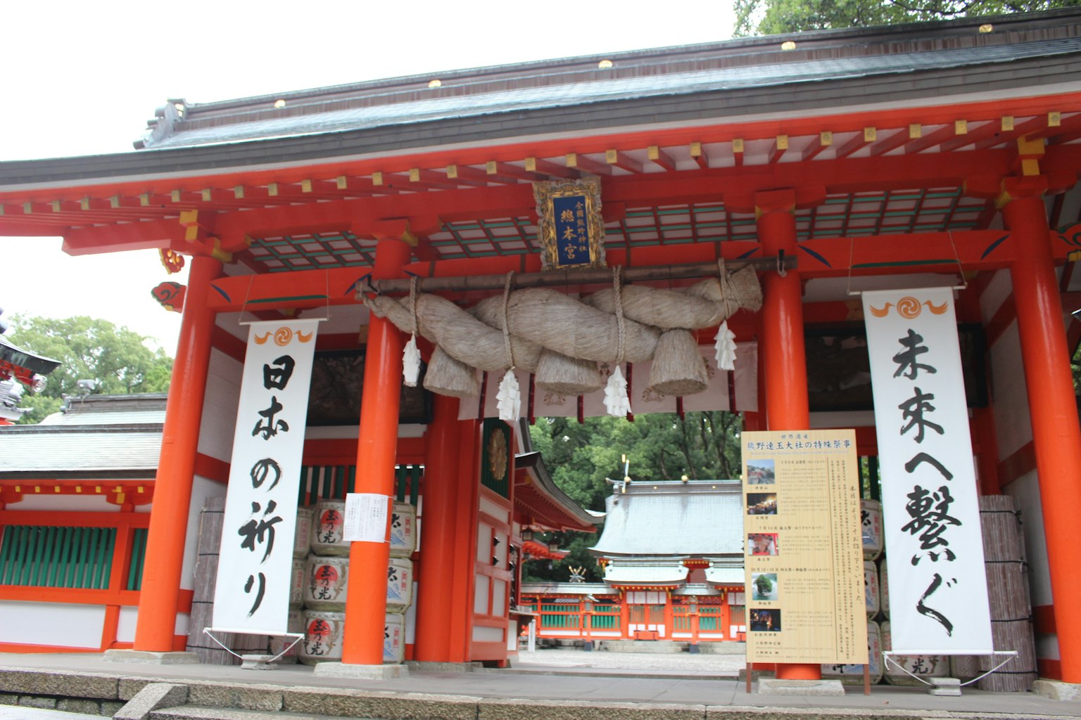 Entrance of a Japanese shrine featuring a red gate and traditional banners
