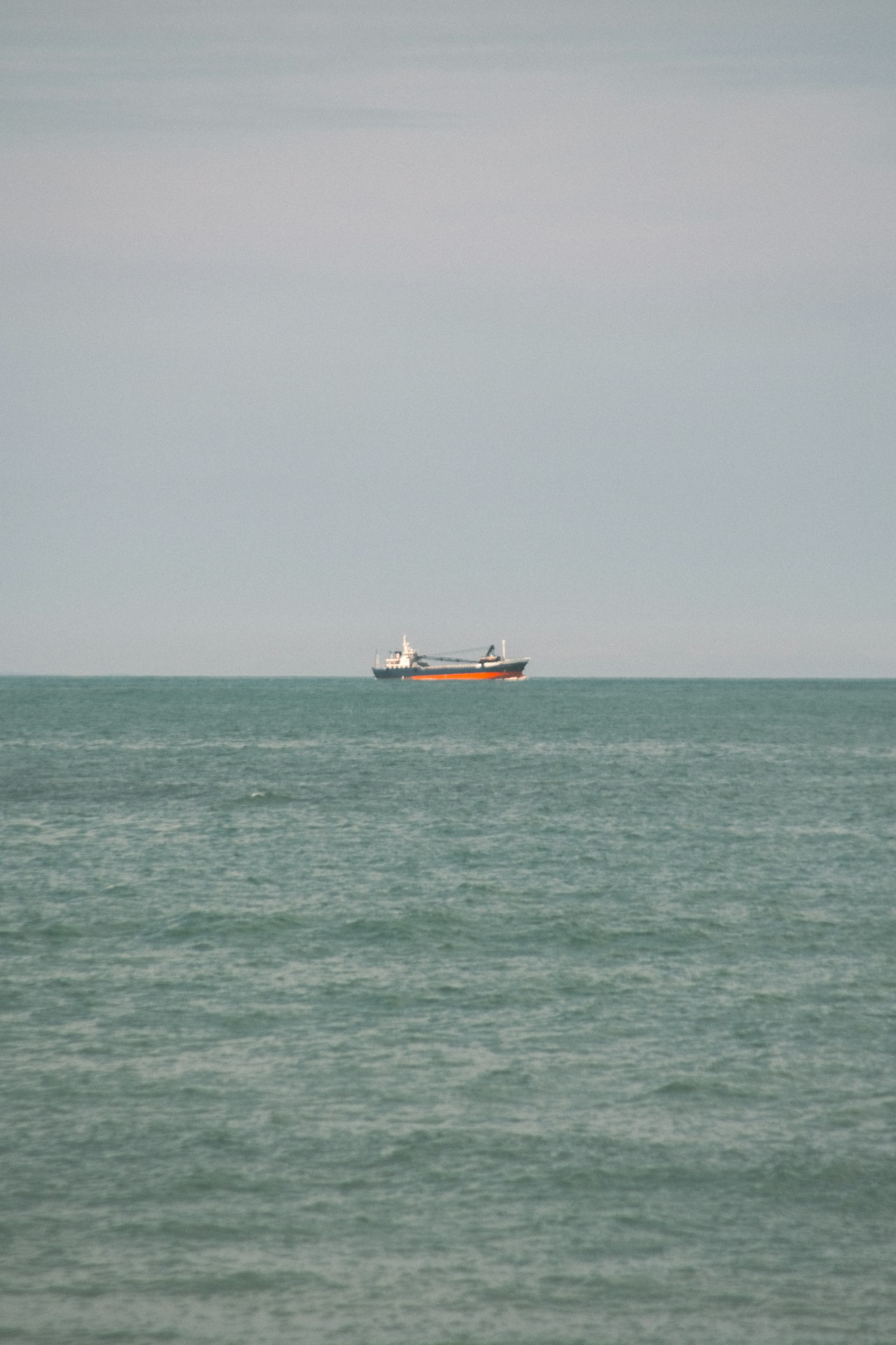 Nave cargo che galleggia sul mare con acqua blu