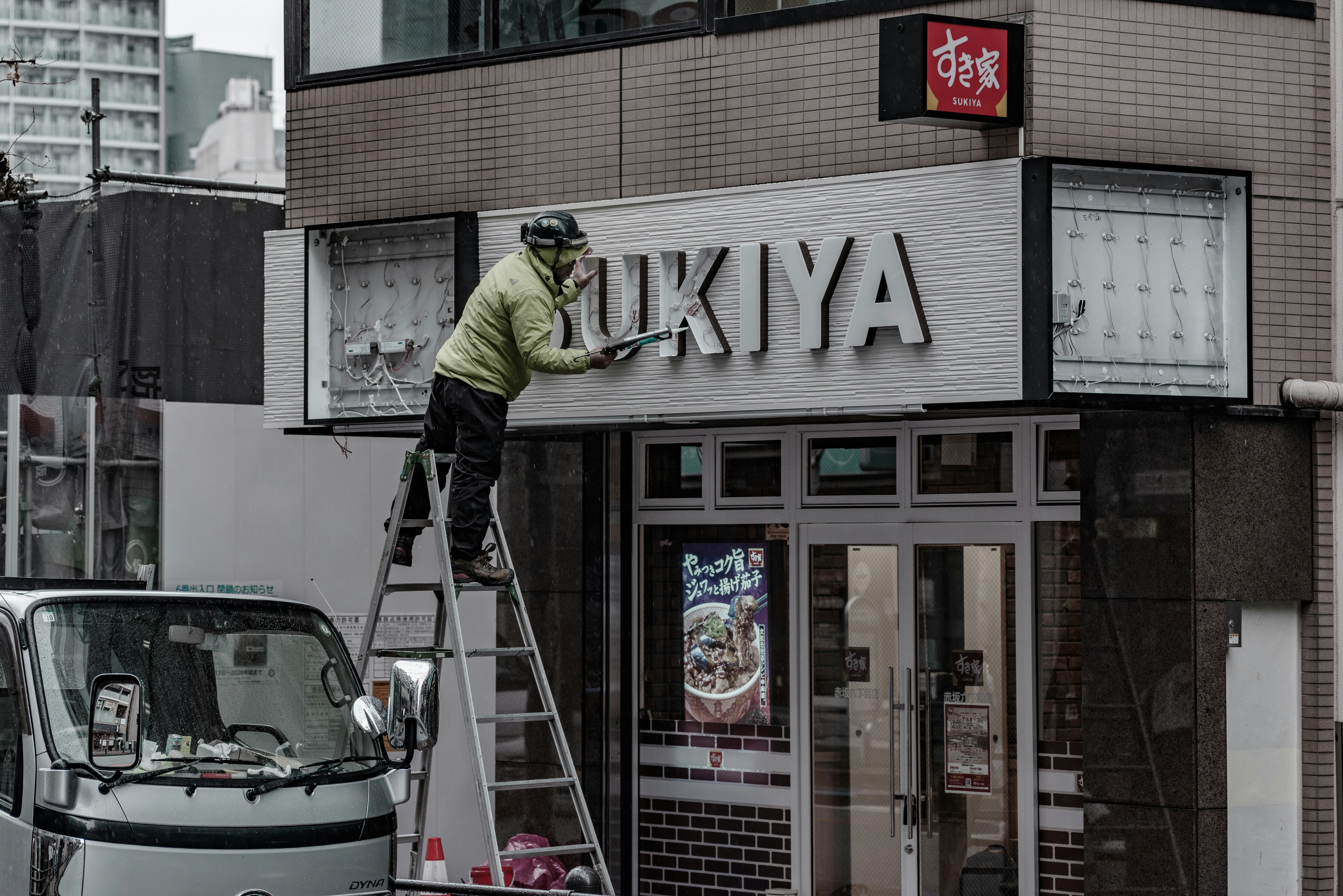 店舗改装中のはしごと作業車のある商店街の外観