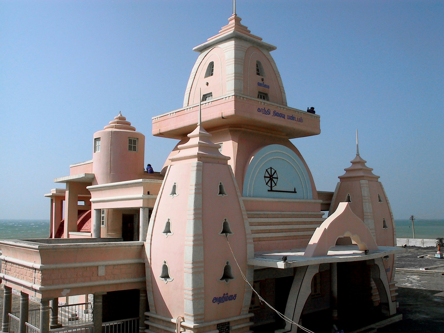 Kuil berwarna pink dengan desain arsitektur unik dan latar belakang lautan