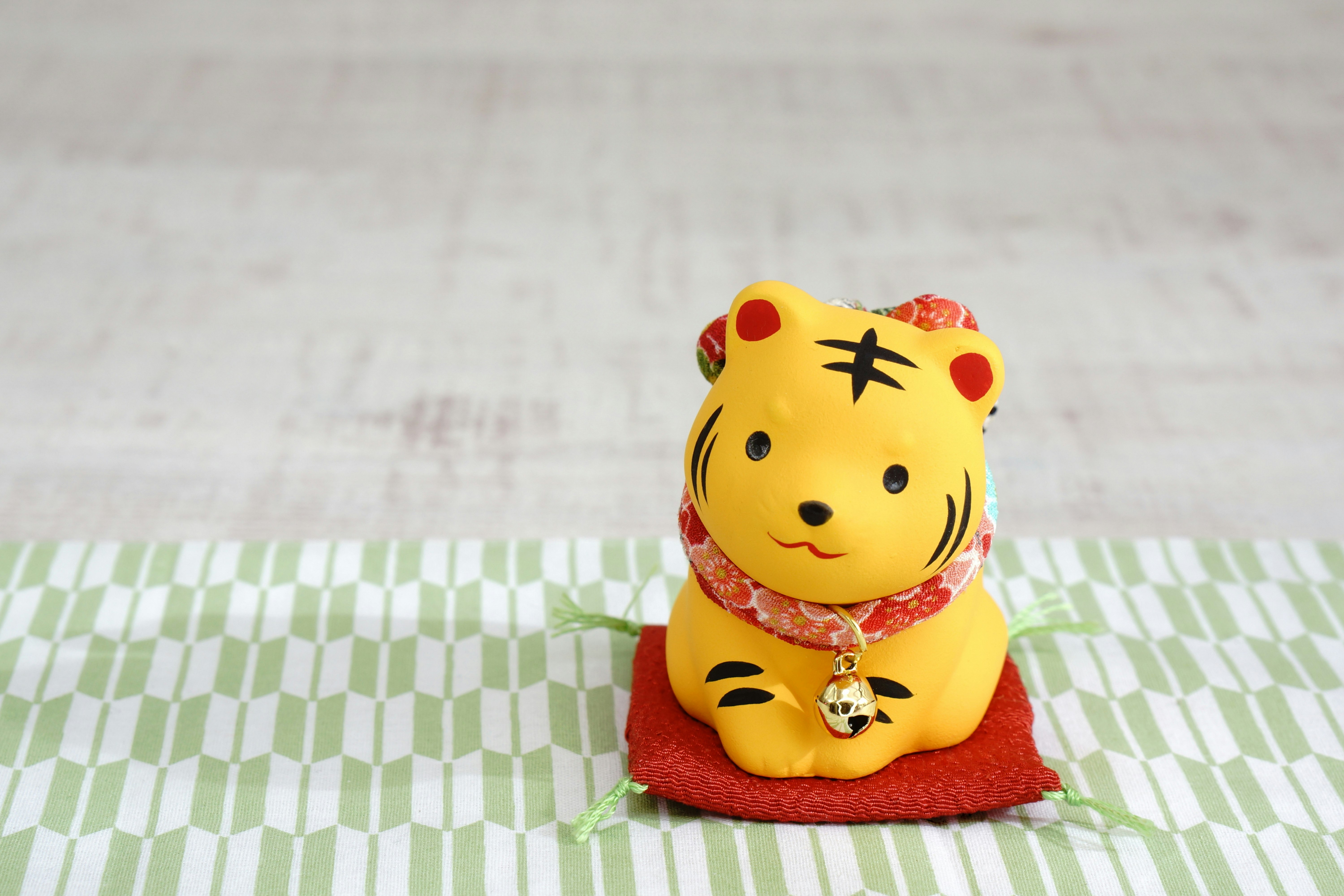 figurine de tigre avec une petite pochette rouge sur un tissu